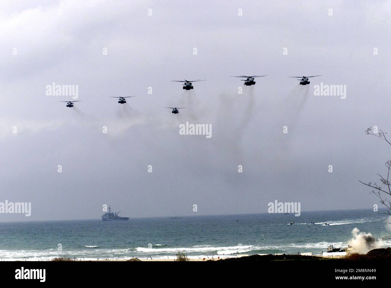 Six US Marine CH-53Es conduct a long range Helo raid, from the USS BONHOMME RICHARD, USS RICHARD and the USS ESSEX (both ships not shown), fly in with Southern Attack Force Marines to defend the airfield. The ship in the background appears to be the Converted Raleigh Class, Command Ship, USS LE SALLE (AGF-3). While minefield breach assault continues below, during rehearsals for Kernel Blitz '99. Subject Operation/Series: KERNEL BLITZ '99 Base: Marine Corps Base Camp Pendleton State: California (CA) Country: United States Of America (USA) Stock Photo