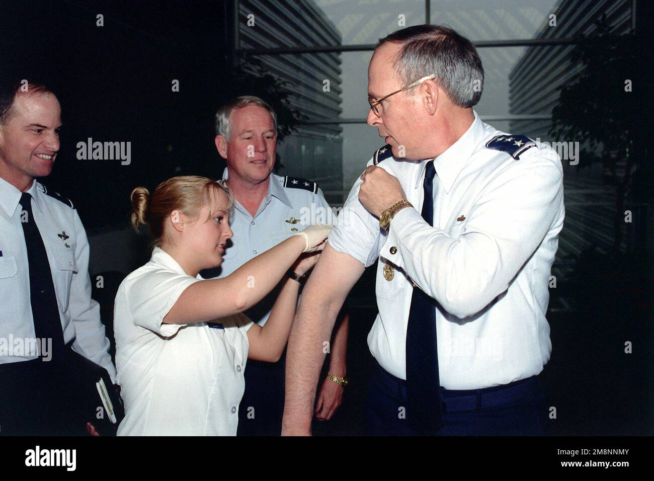 US Air Force Lieutenant General Lance W. Lord (Right), Vice Commander, Air Force Space Command, Peterson Air Force Base, Colorado, receives a flu shot while USAF Major General William R. Looney III (Center), Commander, Space Warfare Center, Schriever AFB, CO, looks on at Peterson AFB, CO, on April 29th, 1999. Base: Peterson Air Force Base State: Colorado (CO) Country: United States Of America (USA) Stock Photo