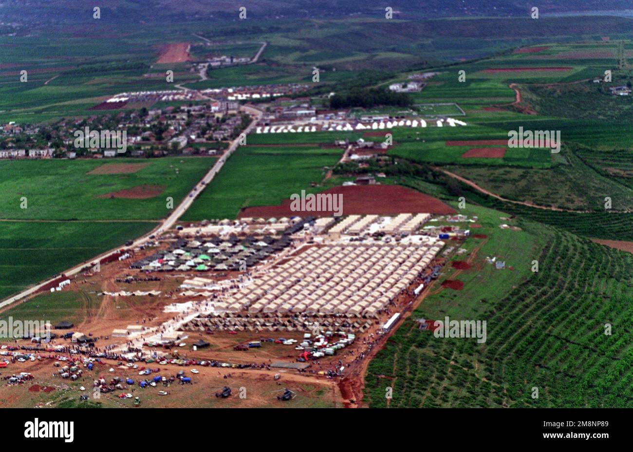 An aerial of a refugee camp near Kukes, Albania, from an MH-53E from HM-15. HM-15 is currently embarked on the Amphibious Assault ship, USS INCHON, (MCS 12) (not shown), USS INCHON which is operating in the Mediterranean and Adriatic Sea, supporting Operation Sustain Hope, a joint, combined NATO and U.S. military humanitarian relief effort in conjunction with civilian relief agencies. Operation Sustain Hope is bringing relief to thousands of refugees created from the recent unrest in the Kosovo region. Subject Operation/Series: SUSTAIN HOPE Base: Kukes Country: Albania (ALB) Stock Photo