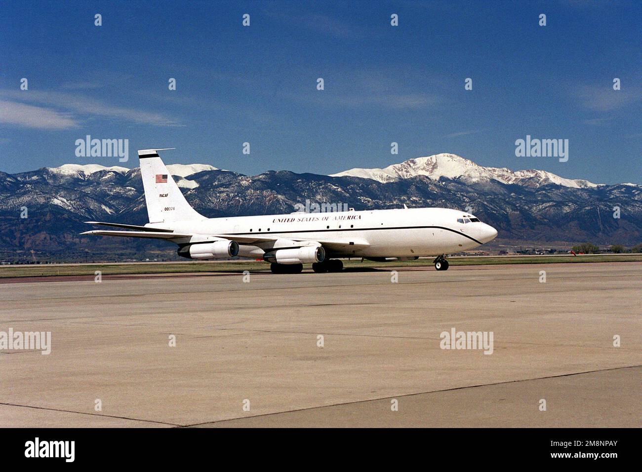 A Boeing 707 aircraft with a US Air Force designation of VC-137, from Pacific Air Force at Hickam Air Force Base, Hawaii, taxis on the Peterson AFB, Colorado, flight line with Pikes Peak in the background. Base: Peterson Air Force Base State: Colorado (CO) Country: United States Of America (USA) Stock Photo
