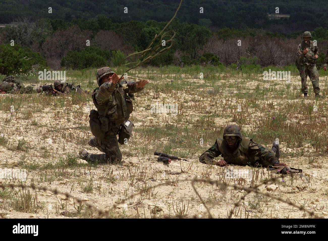 Straight on, medium shot of US Army Soldiers from Alpha Company, 1ST of the  9th Cavalry, 1ST Cavalry Division, as they navigate a mine field utilizing  a grappling hook prior to cutting