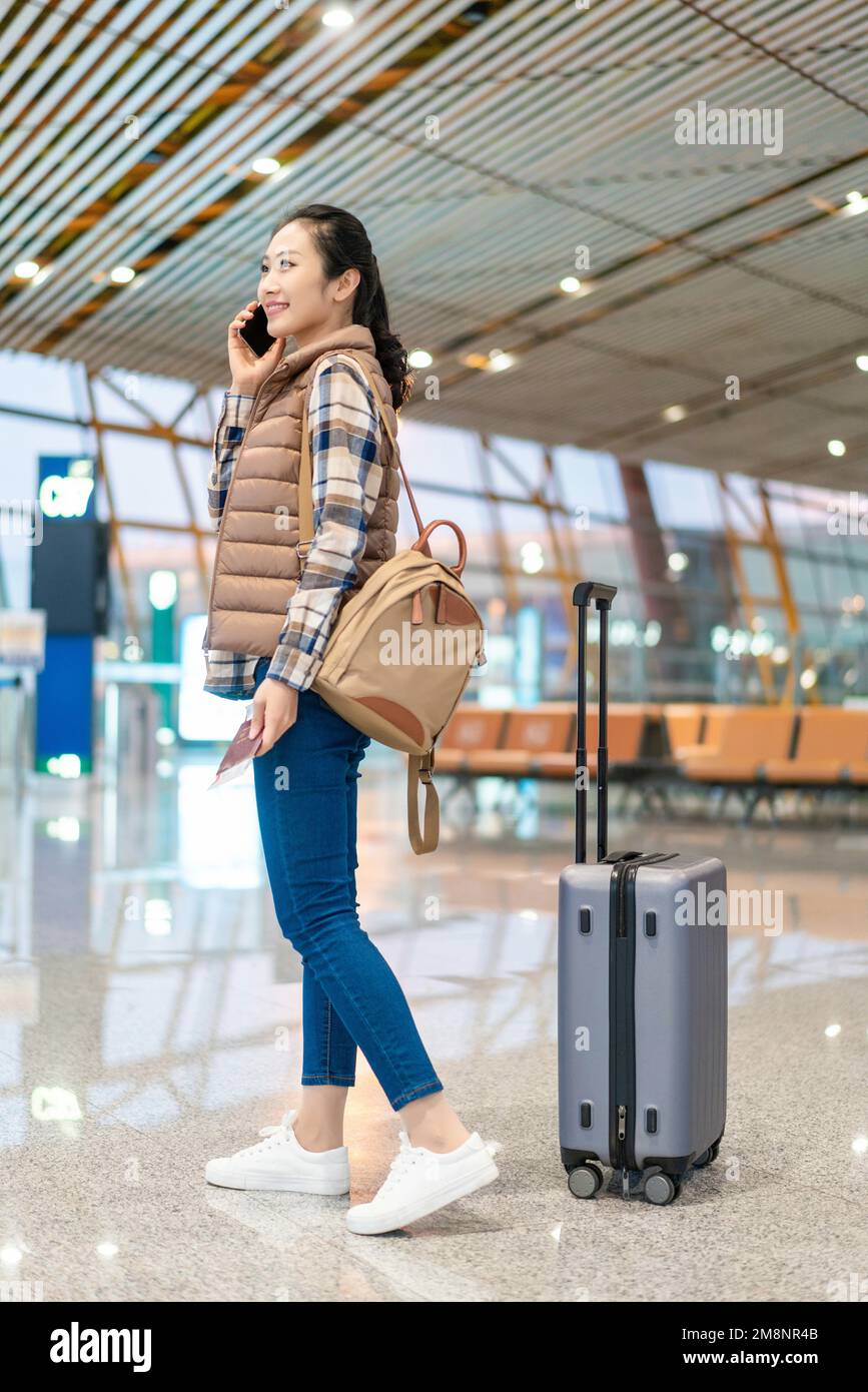 A young woman in the airport lounge on the phone Stock Photo - Alamy