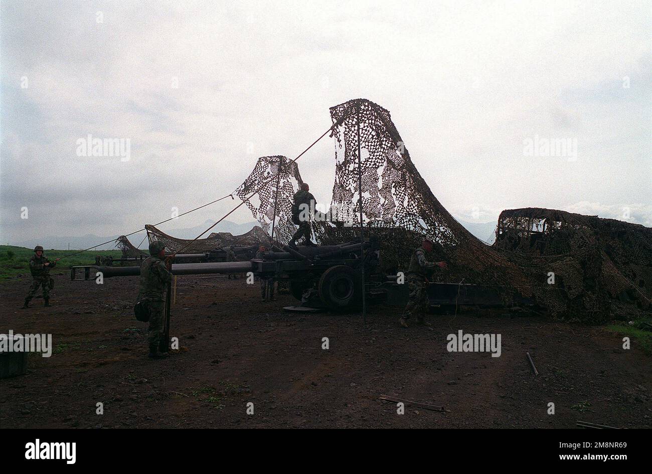 Marines deploy concealment netting used to camouflage their 5ton trucks and 155 mm Howitzers at