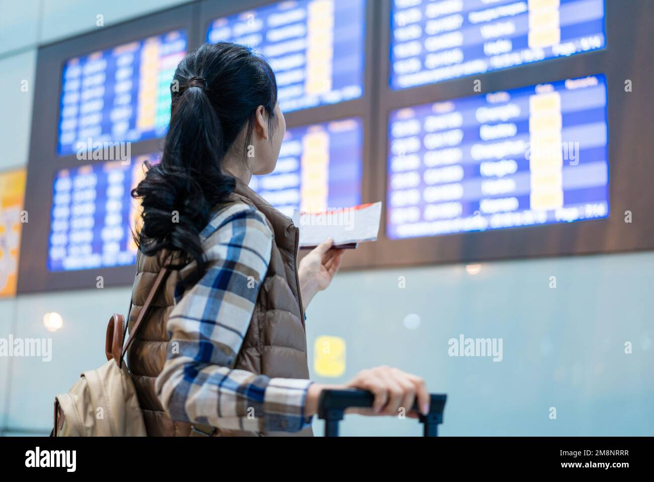 A young woman to check the flights Stock Photo - Alamy