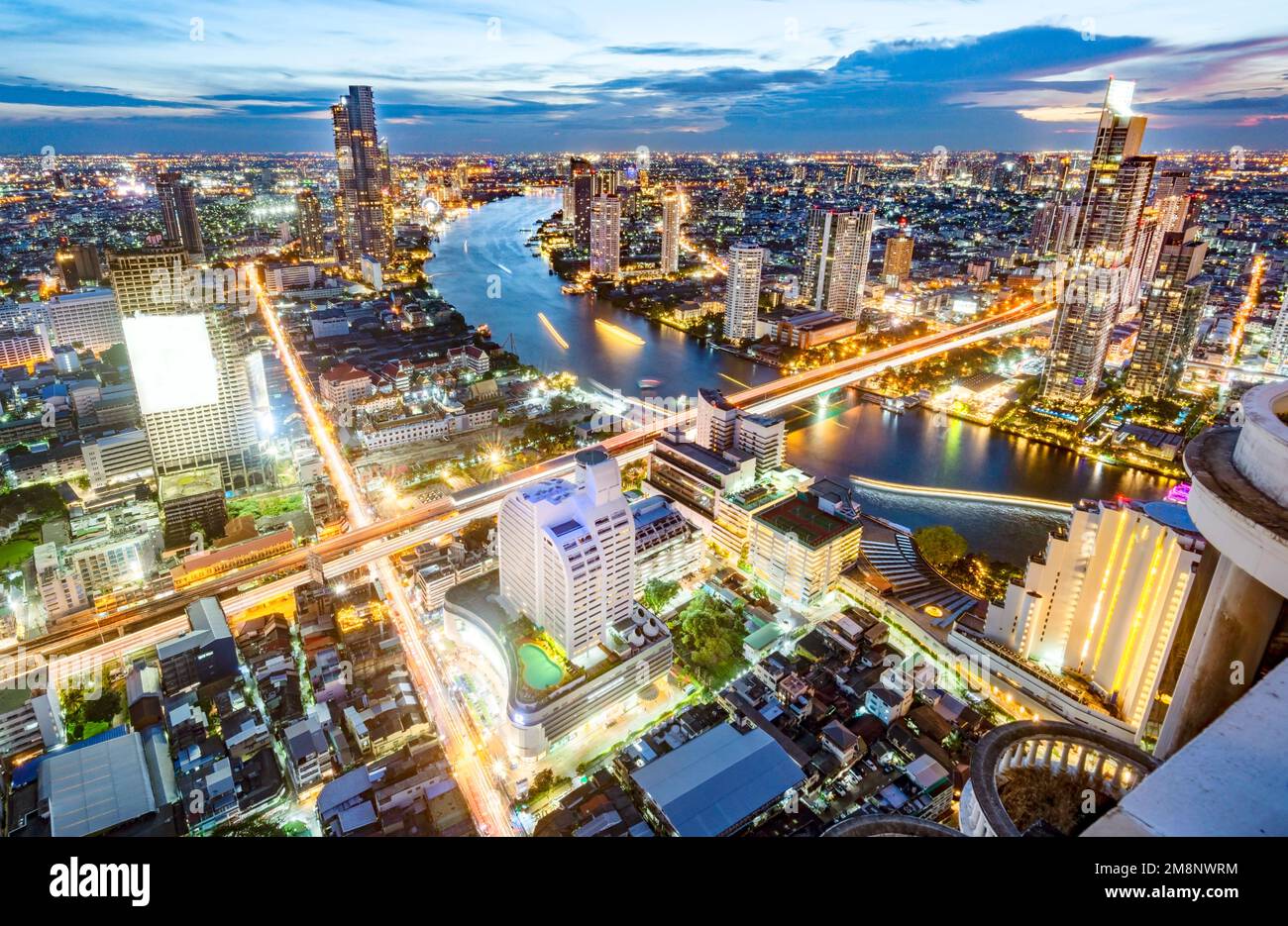 Bangkok,Thailand-December 04 2022: Viewed from a skyscraper rooftop, thousands of lights illuminate Thailand's capital city,and light trails from traf Stock Photo