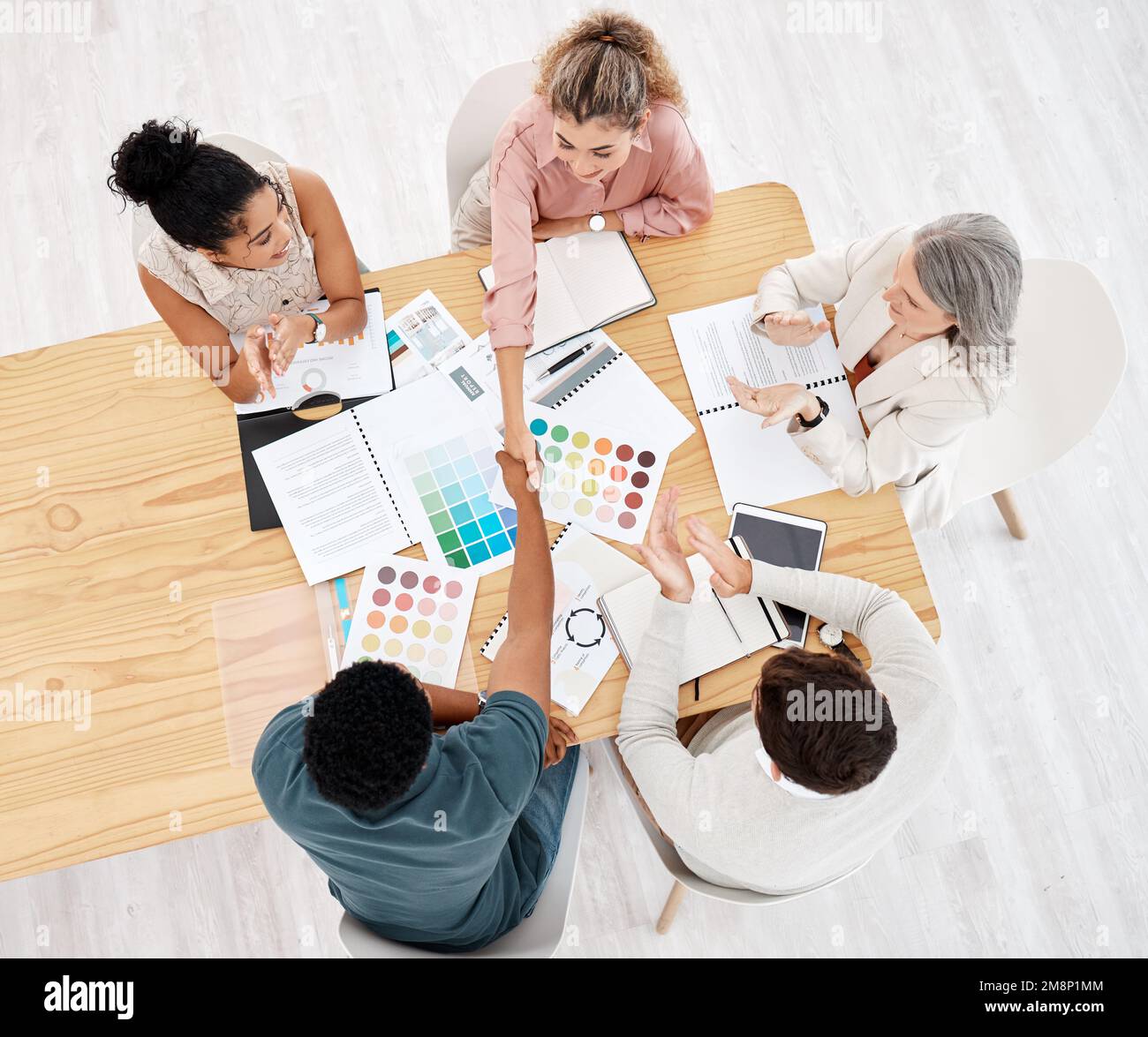 Group of five diverse businesspeople having a meeting at a table in an ...