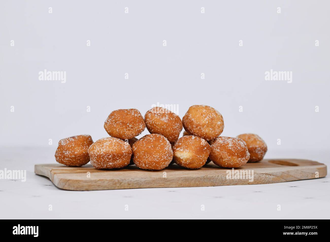 German traditional 'Berliner Pfannkuchen', a donut without hole filled with jam on wooden cutting board Stock Photo