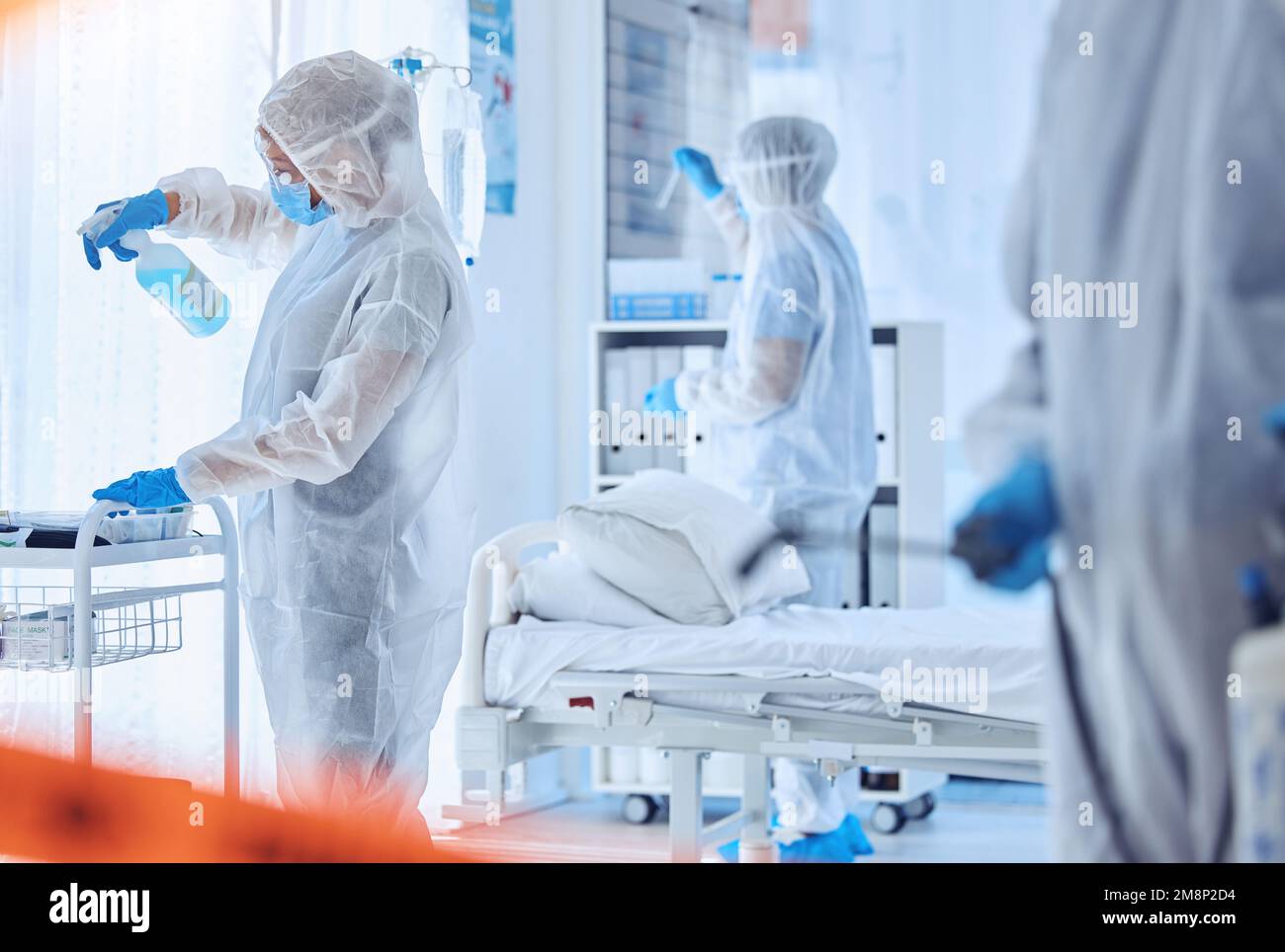 Biohazard team cleaning a medical hospital. Csi team in hazmat suits cleaning a protected quarantined area. Biochemist colleagues collaborate to Stock Photo