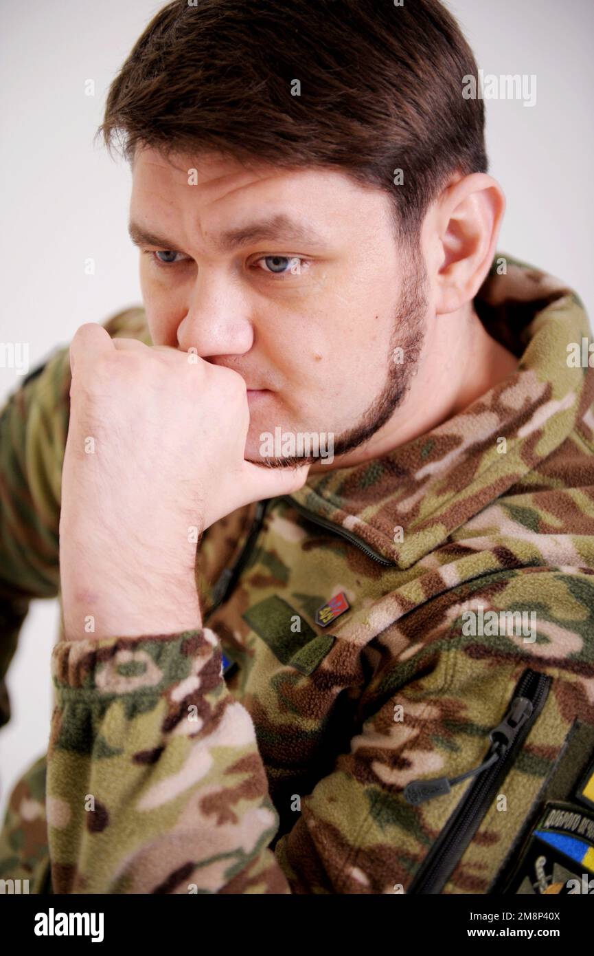 adult handsome man soldier a company commander thought about the plan  leaned on his arm and decides what to do next he wears a khaki military  uniform Stock Photo - Alamy