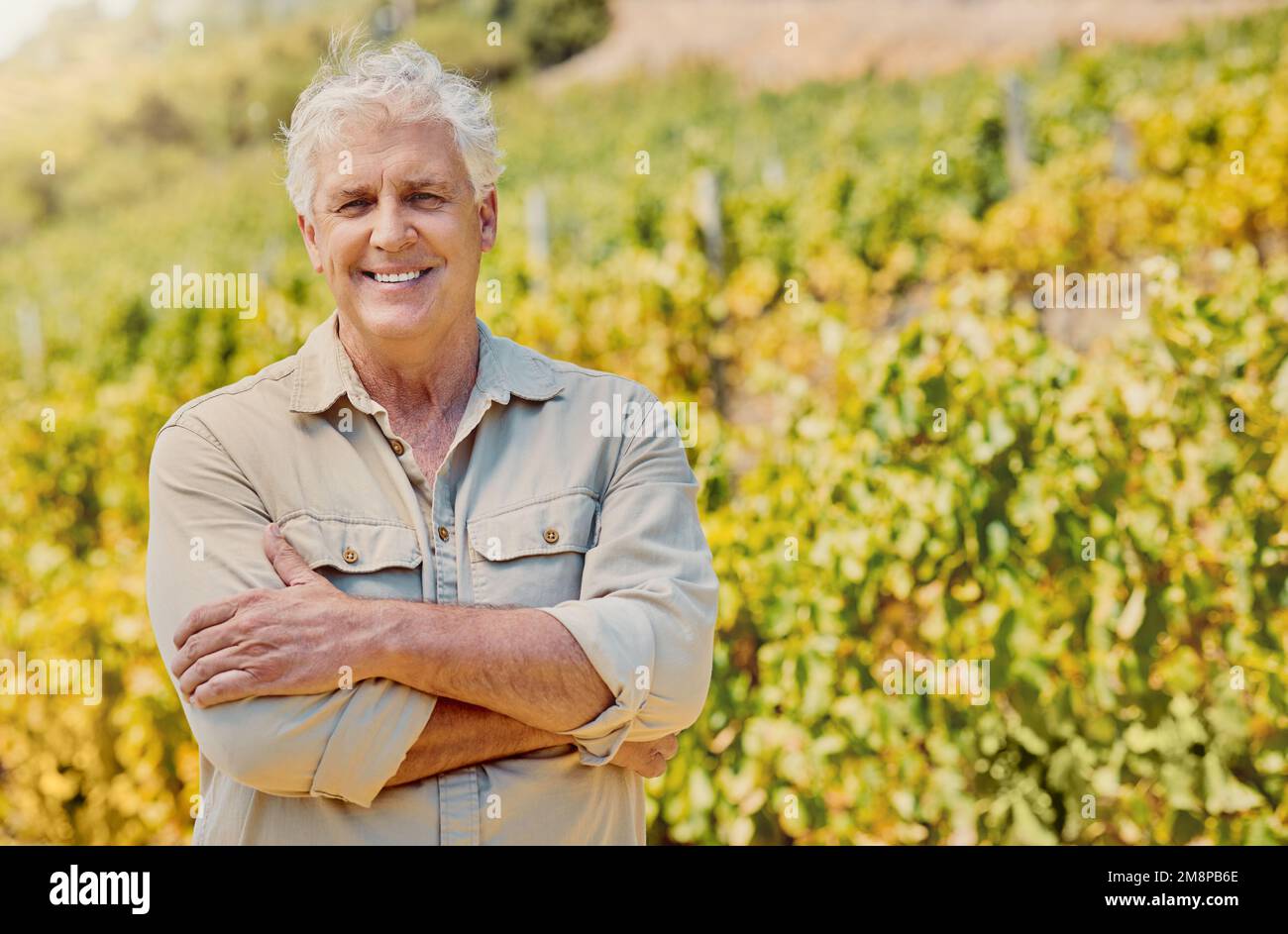 Smiling senior caucasian confident farmer standing alone with his arms ...