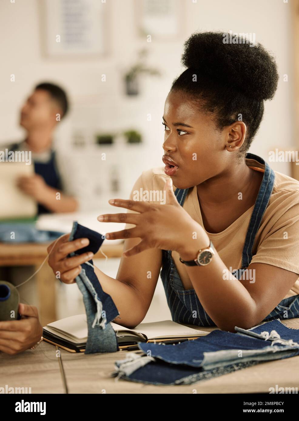 African american designer talking about denim sample. Young seamstress ...