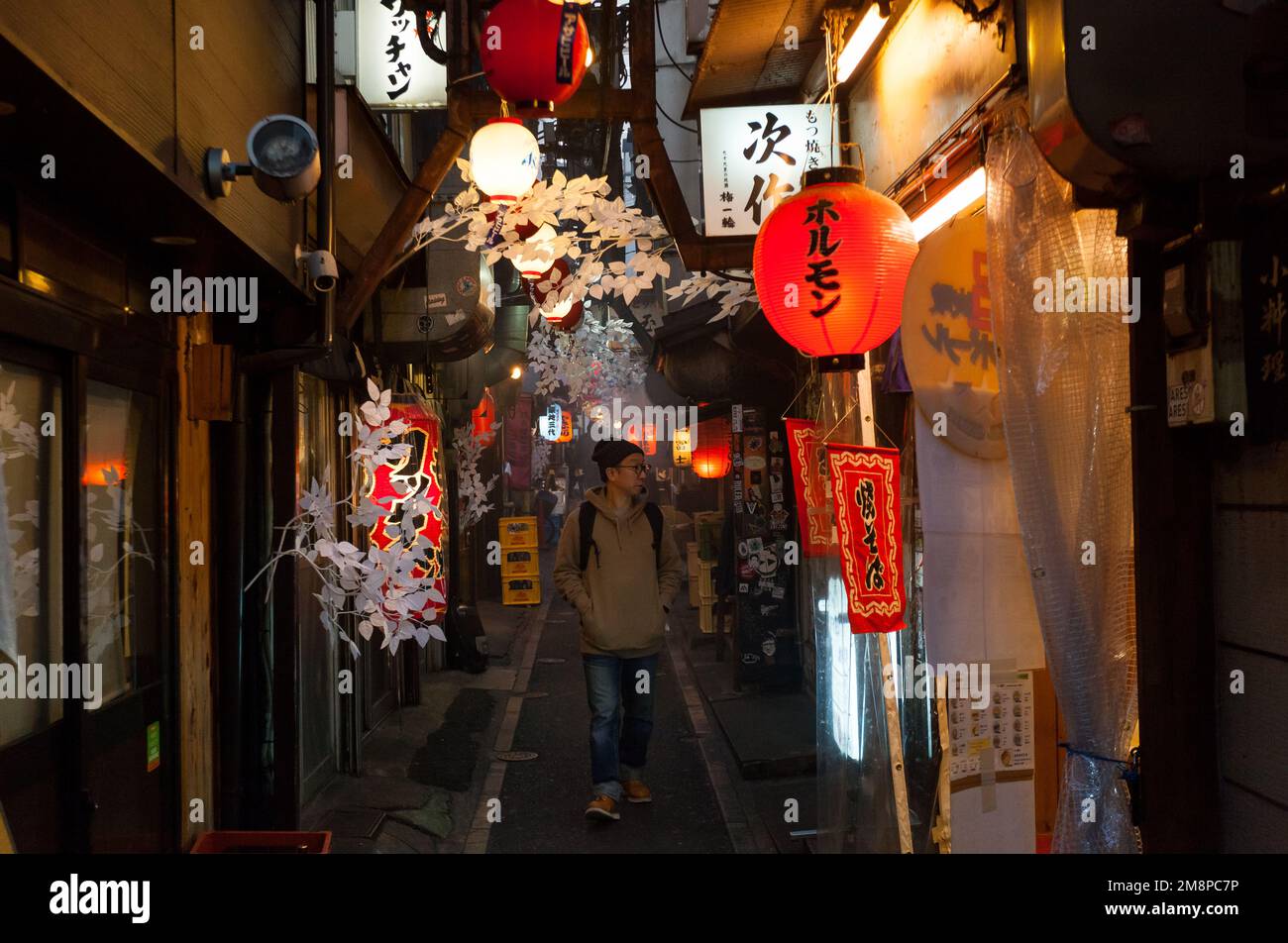 A Japanese man walks through Omoide Yokocho (Welcome Alley though often known as Piss Alley) Shinjuku, Tokyo, Japan Stock Photo