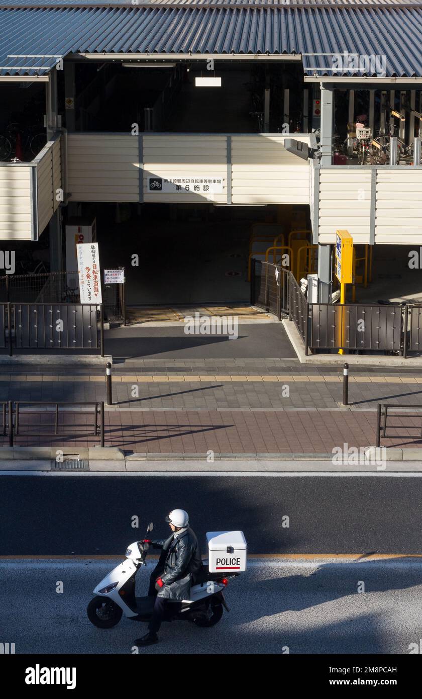 A Japanese police office on a moped in Kashimada, Kawasaki, Kanagawa, Japan. Stock Photo