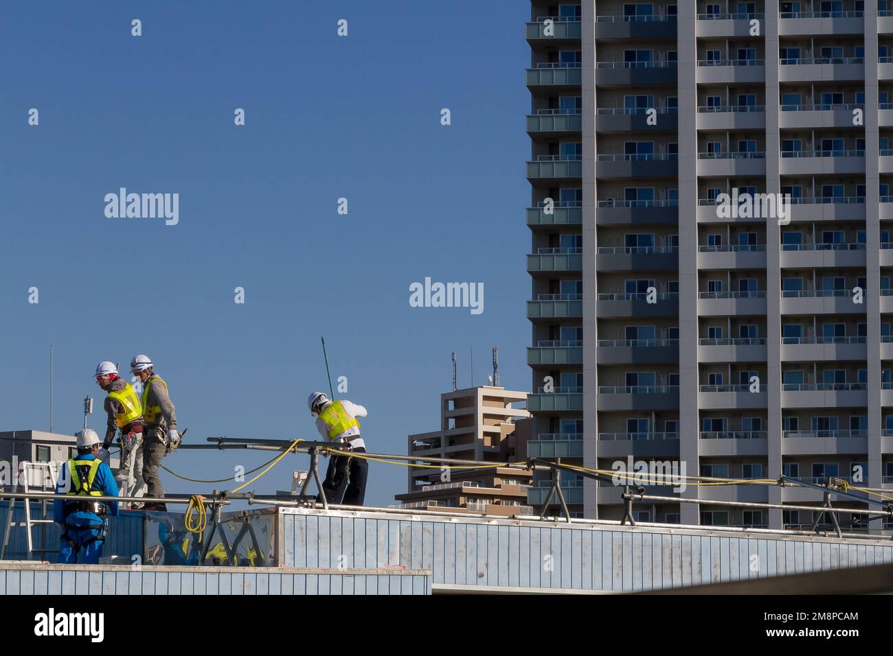 Workmen on the roof of Shin-Kawasaki station in Kashimada, Kawasaki, Kanagawa, Japan. Stock Photo