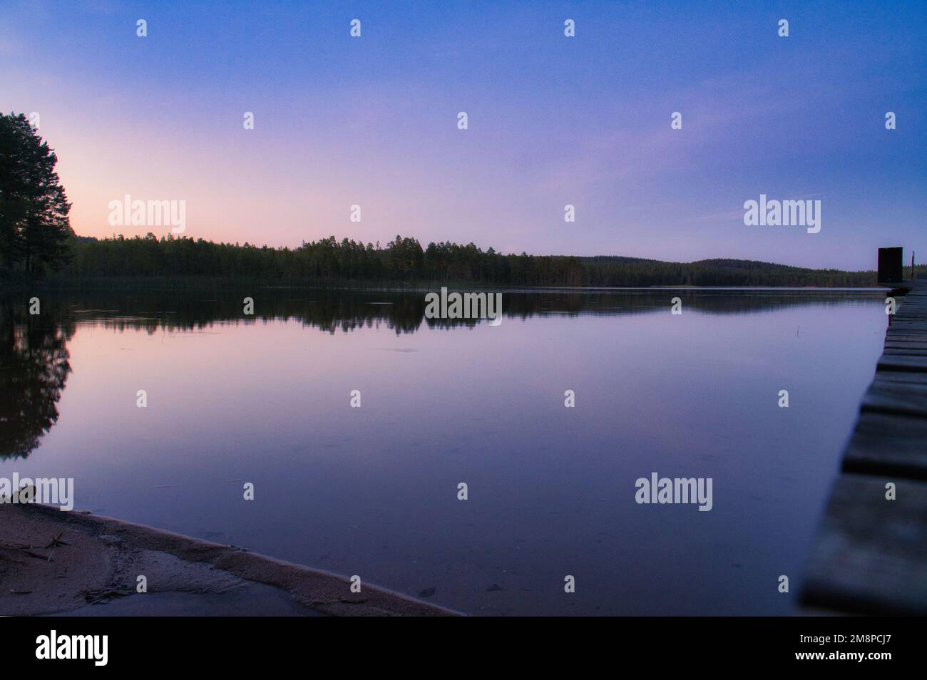 A silhouette of trees by the lake during the sunset Stock Photo - Alamy