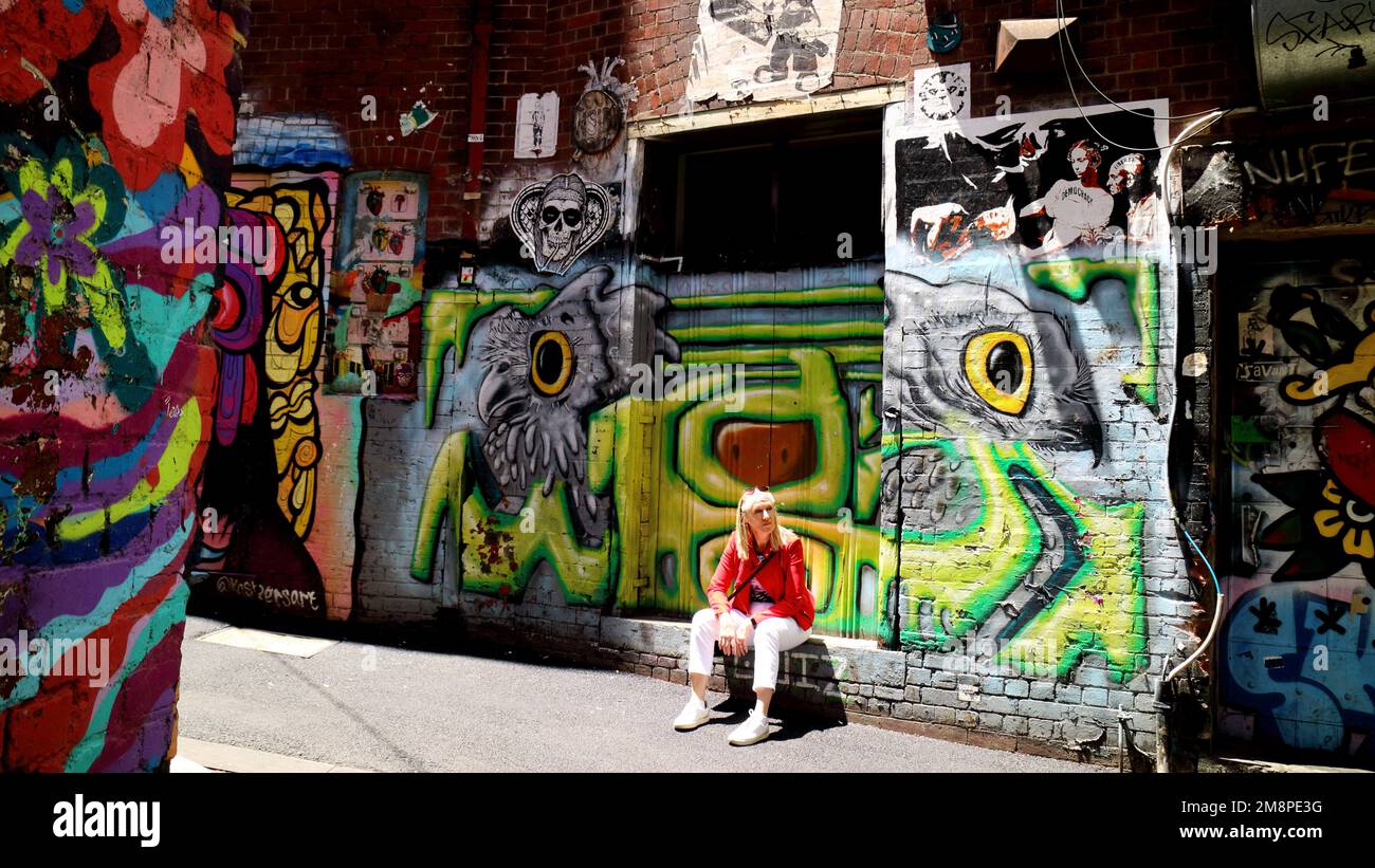 Woman sitting among the graffiti in ACDC Lane in Melbourne Stock Photo ...