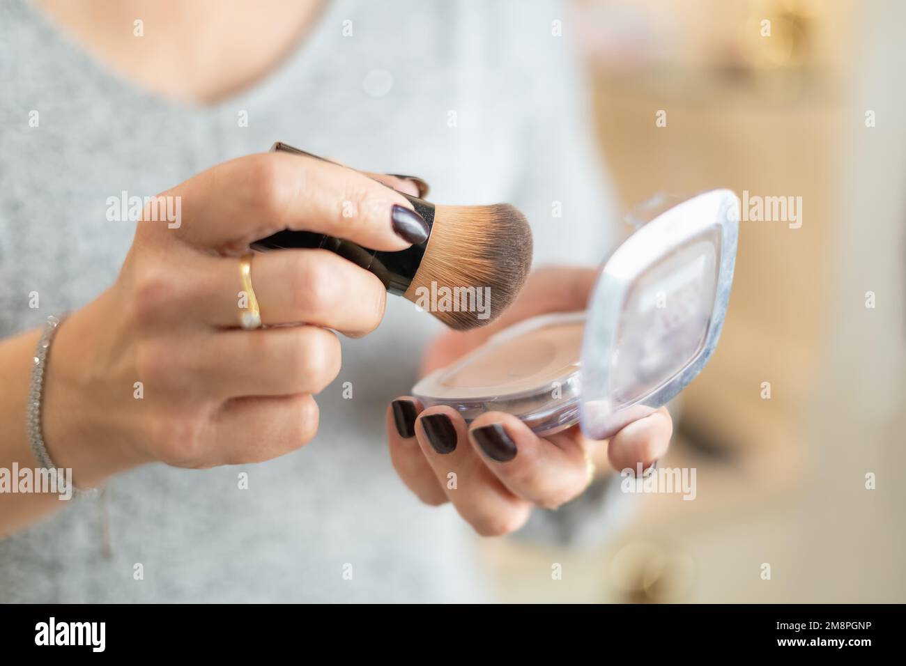 Close-up of older woman's hands handling makeup items. Stock Photo
