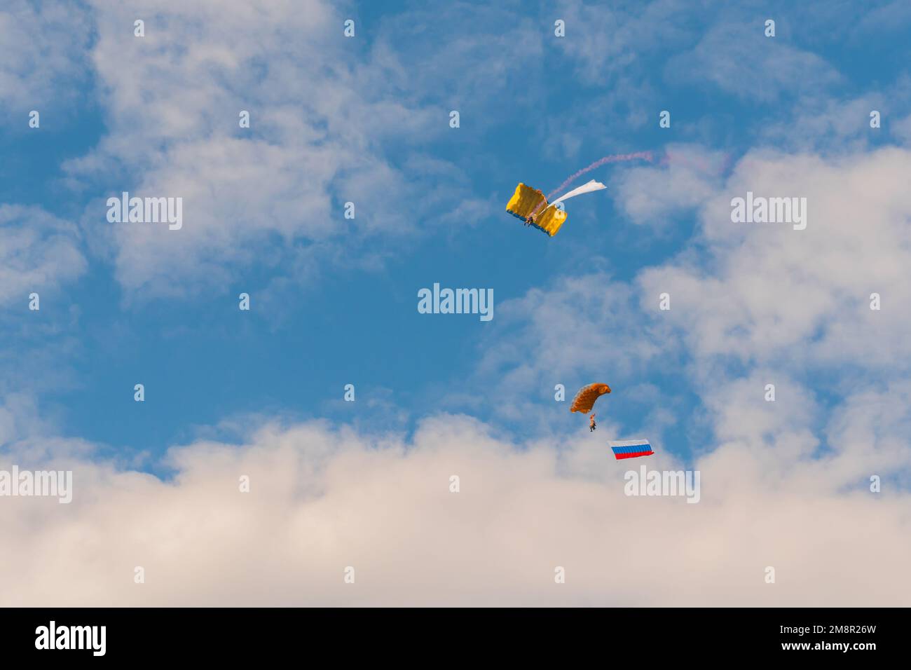 Two skydivers flying with parachute against blue sky - extreme sport concept Stock Photo