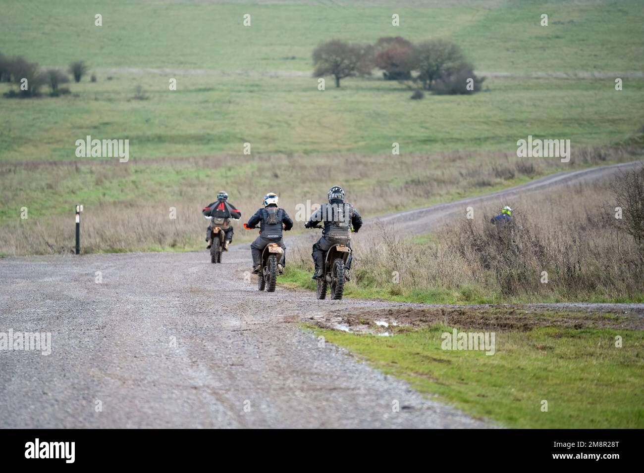 motor cyclists (bikers) riding off-road motorbikes along a stone track on Salisbury Plain, Wiltshire Stock Photo