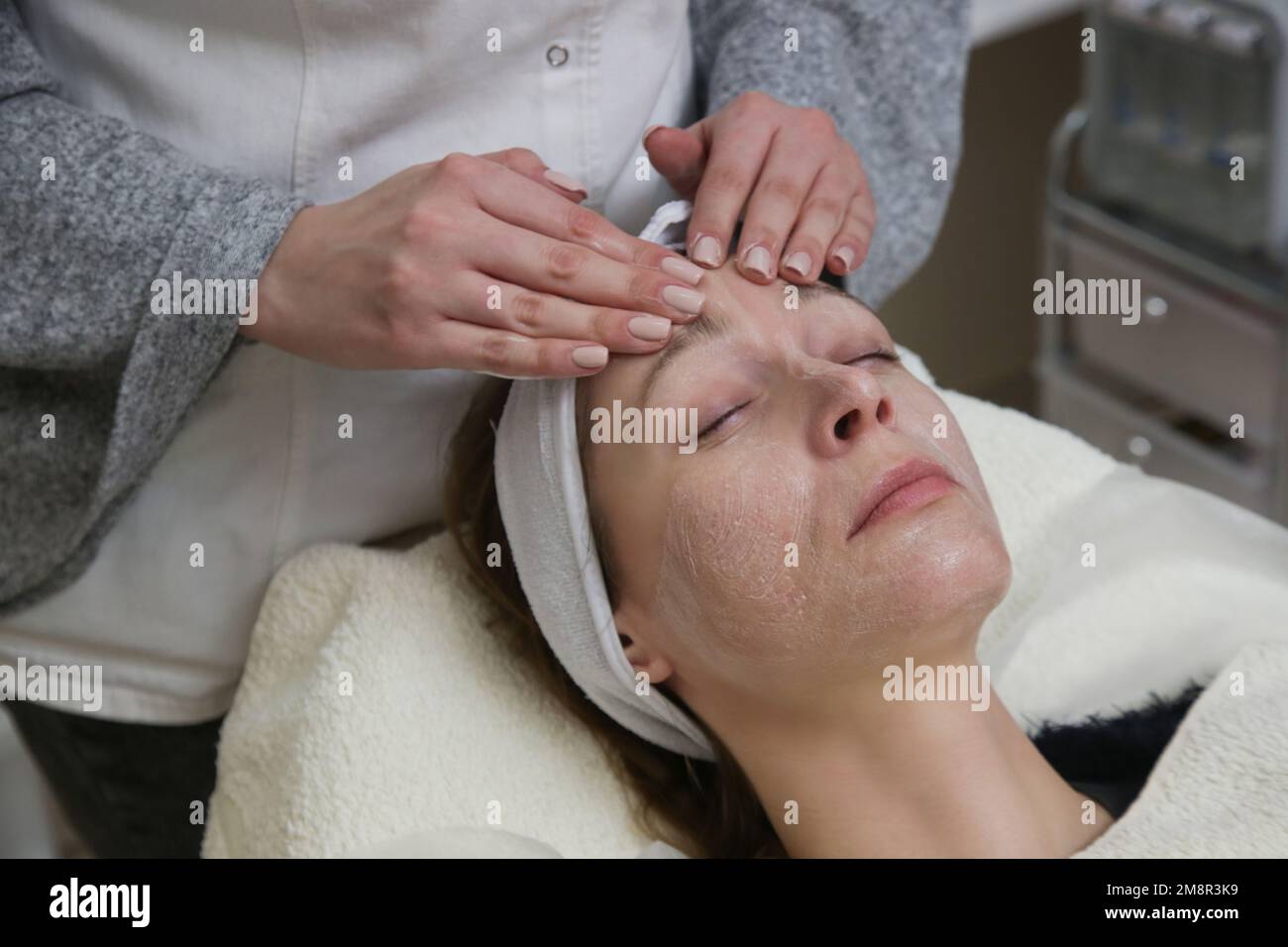 Dermatologist preparing woman's face skin for treatment. Process of