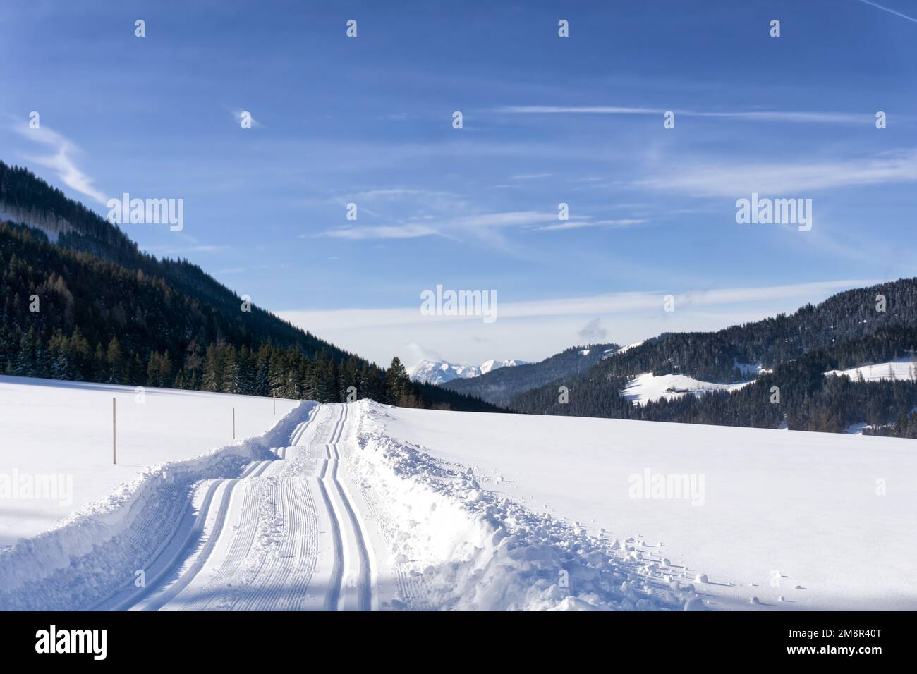 Mountain road in winter with groomed cross-country ski trail in Filzmoos Valley, Salzburg Alps,  Austria, Europe. Winter mountain landscape,  snow cov Stock Photo
