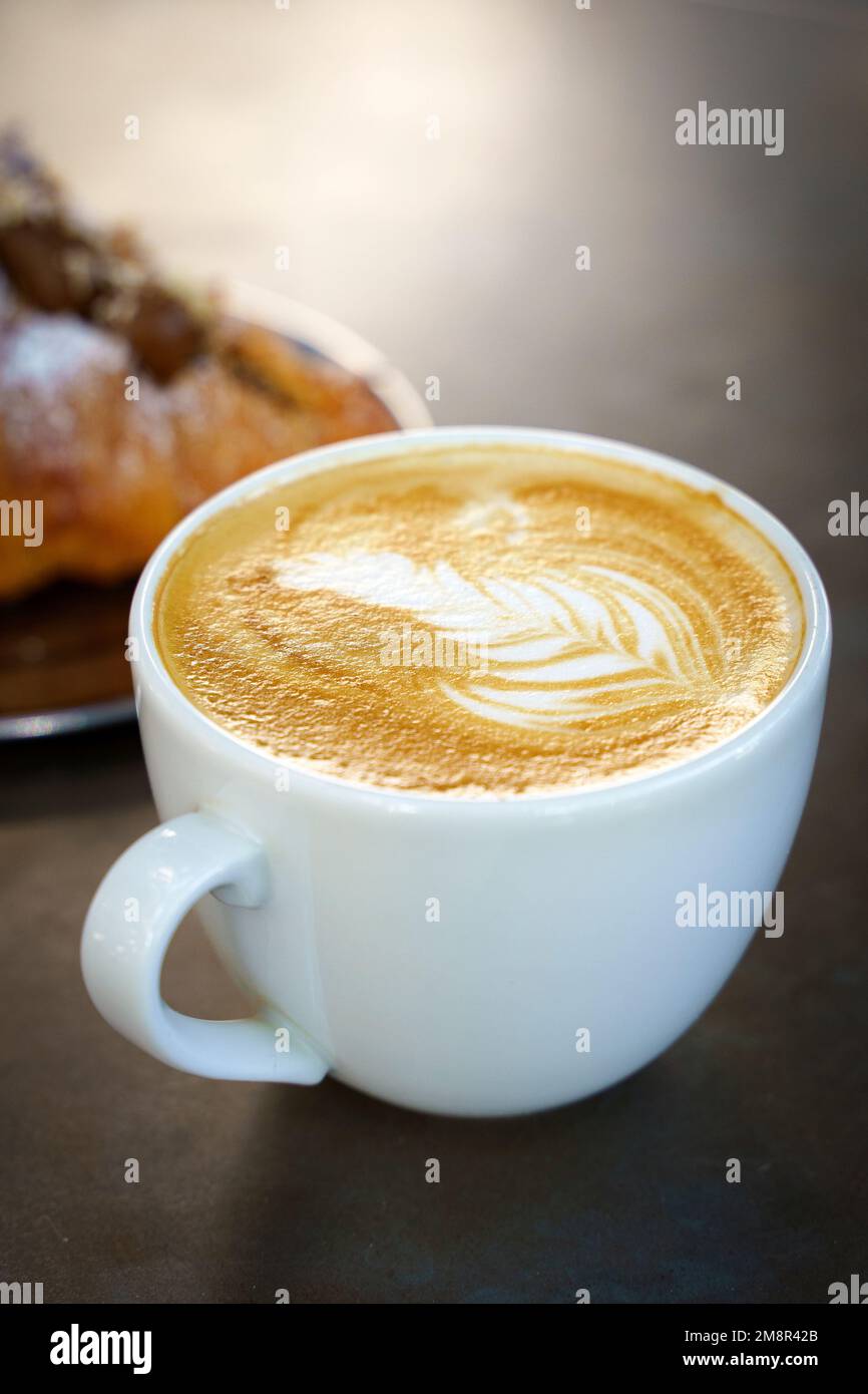 A cup of cappuccino coffee on a table in a cafe. Coffee hot drink in a ceramic cup for breakfast in the morning. High quality photo Stock Photo
