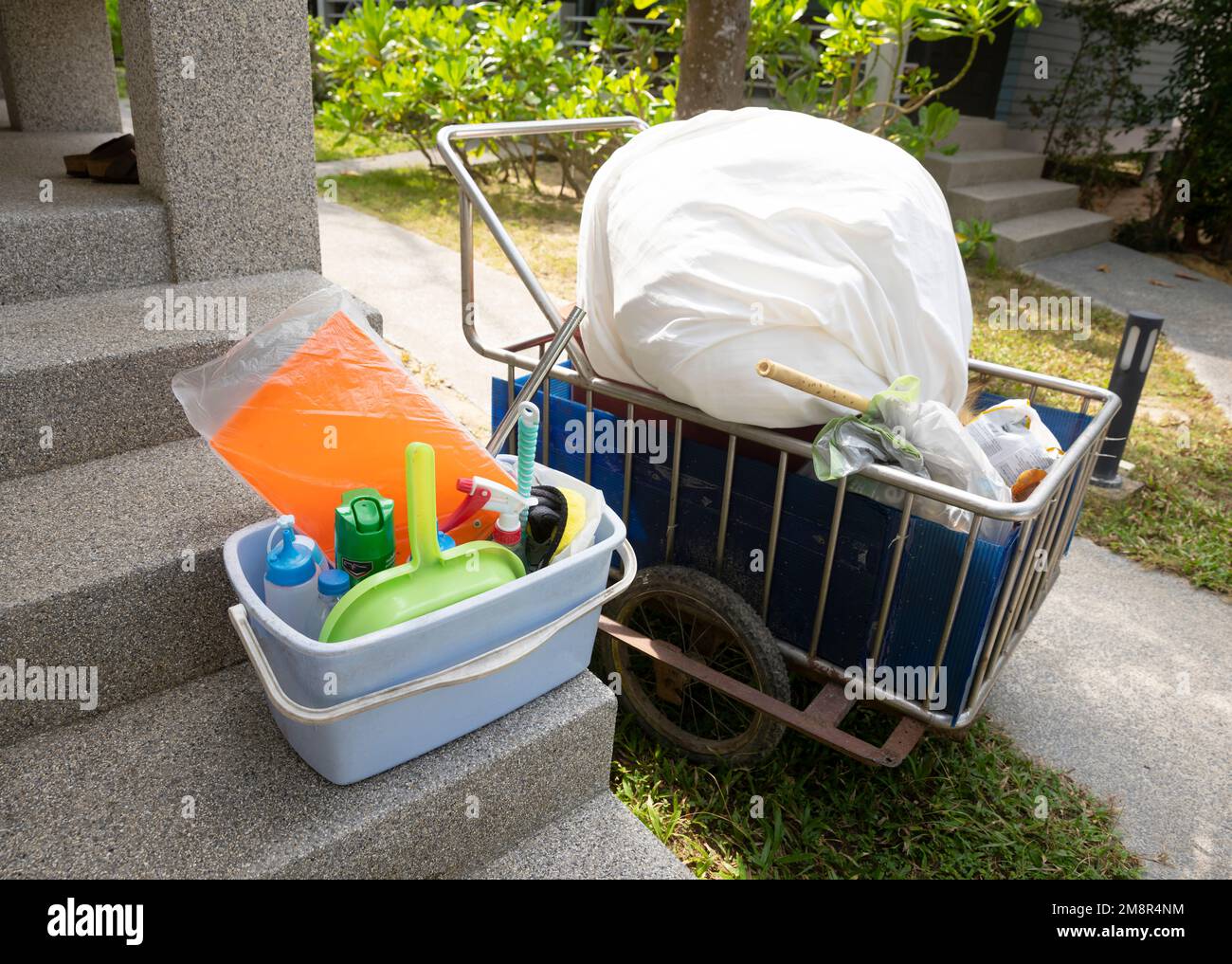 colorful cleaning utensils from cleaning lady and laundry cart stand in