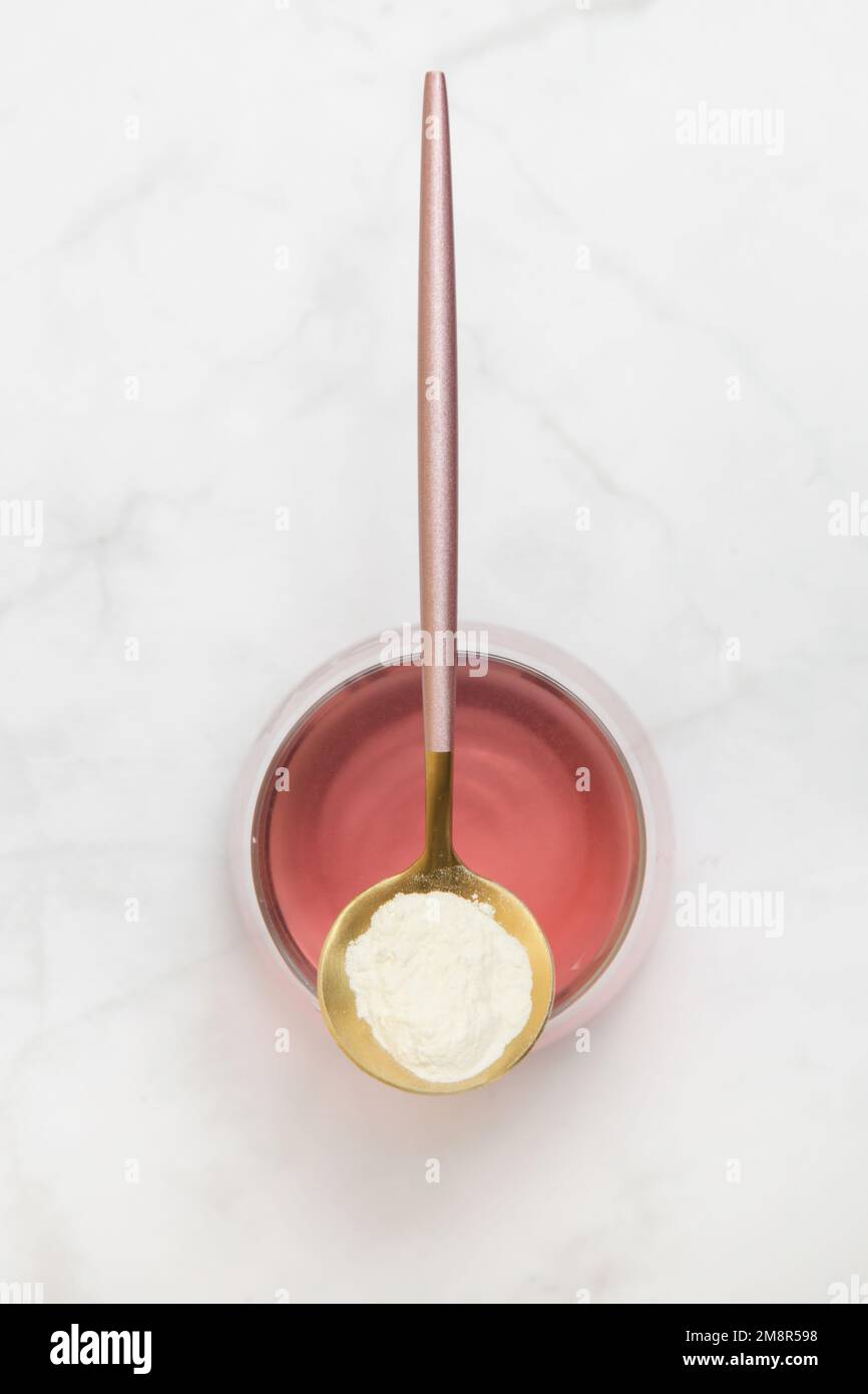 Super food additives. Collagen protein powder, spoon and glass of water
