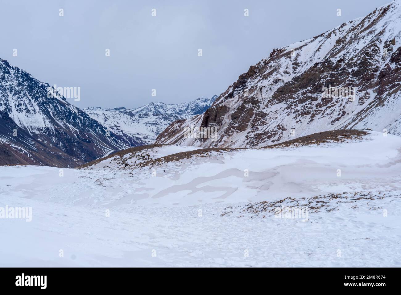An image of mountains covered by snow under the cloudy blue sky Stock ...