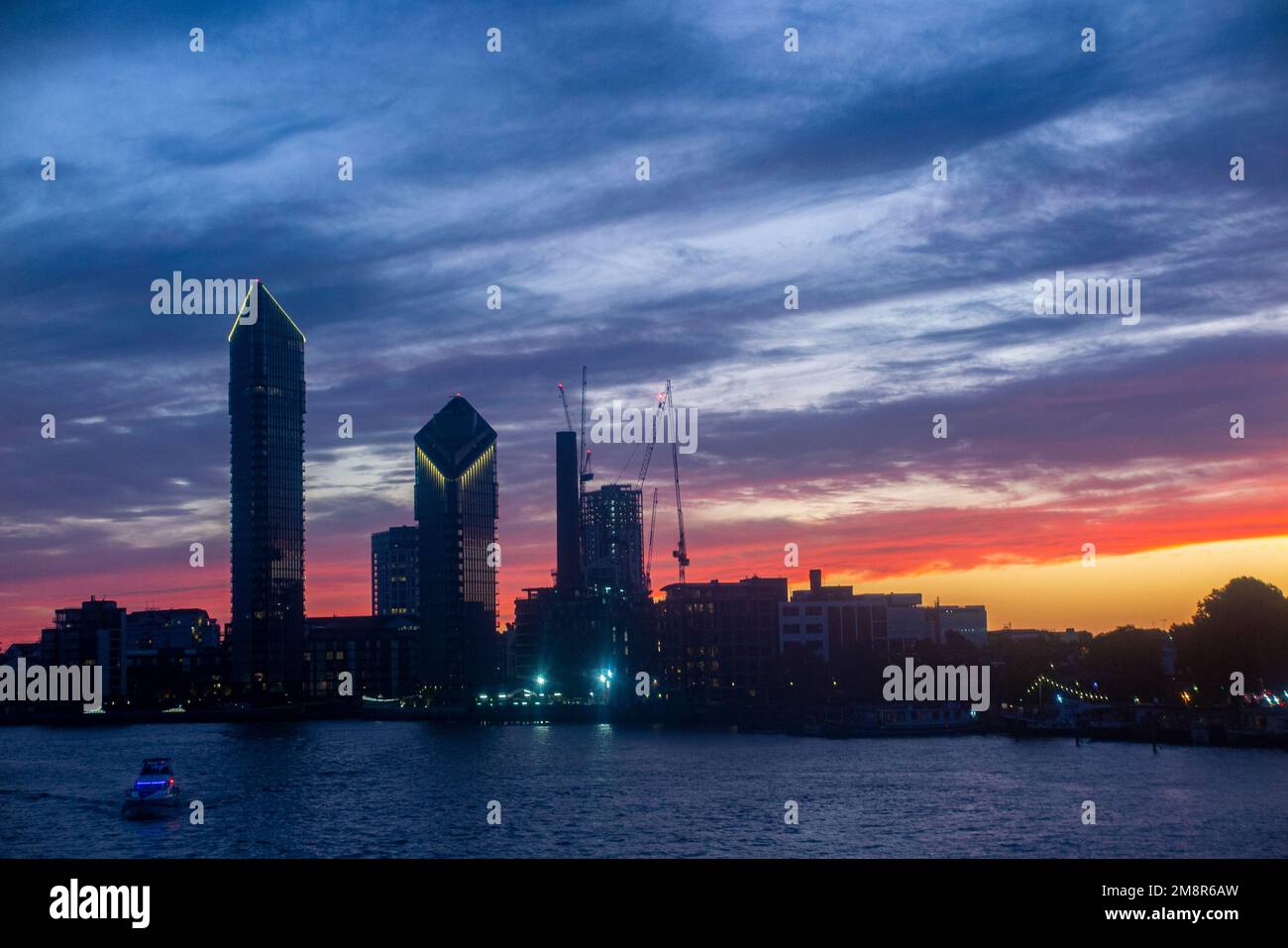 The Chelsea Waterfront skyline on the River Thames at sunset with Tower
