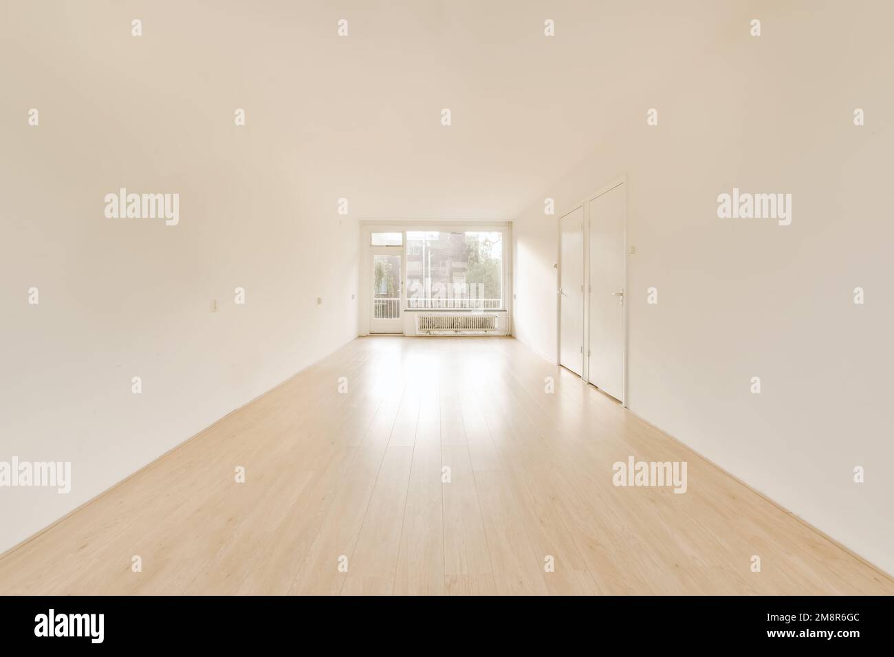 an empty room with white walls and hardwood flooring in the middle part of the room is light wood floors Stock Photo