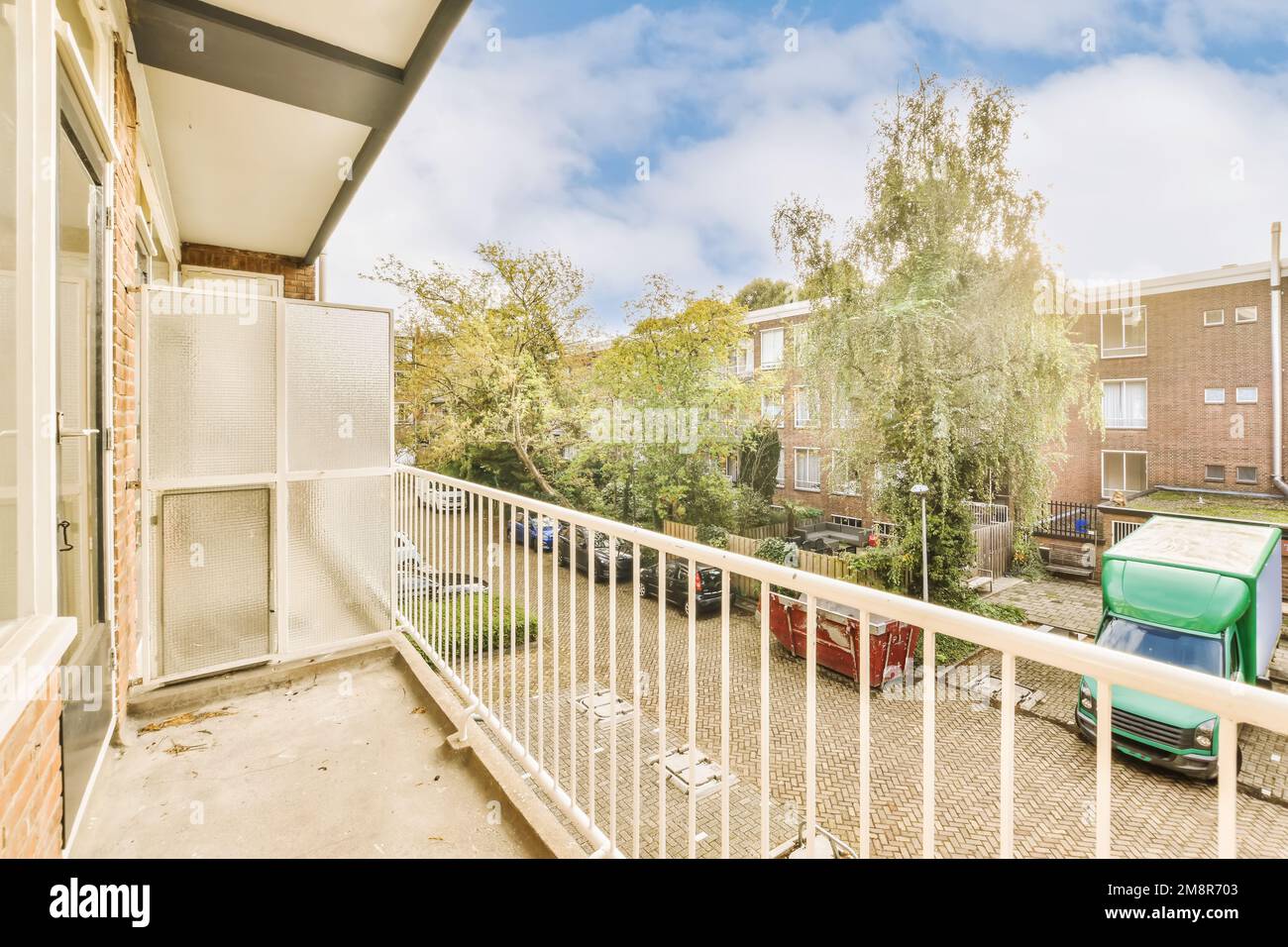 an outside area with some trees and cars on the street in front of a ...