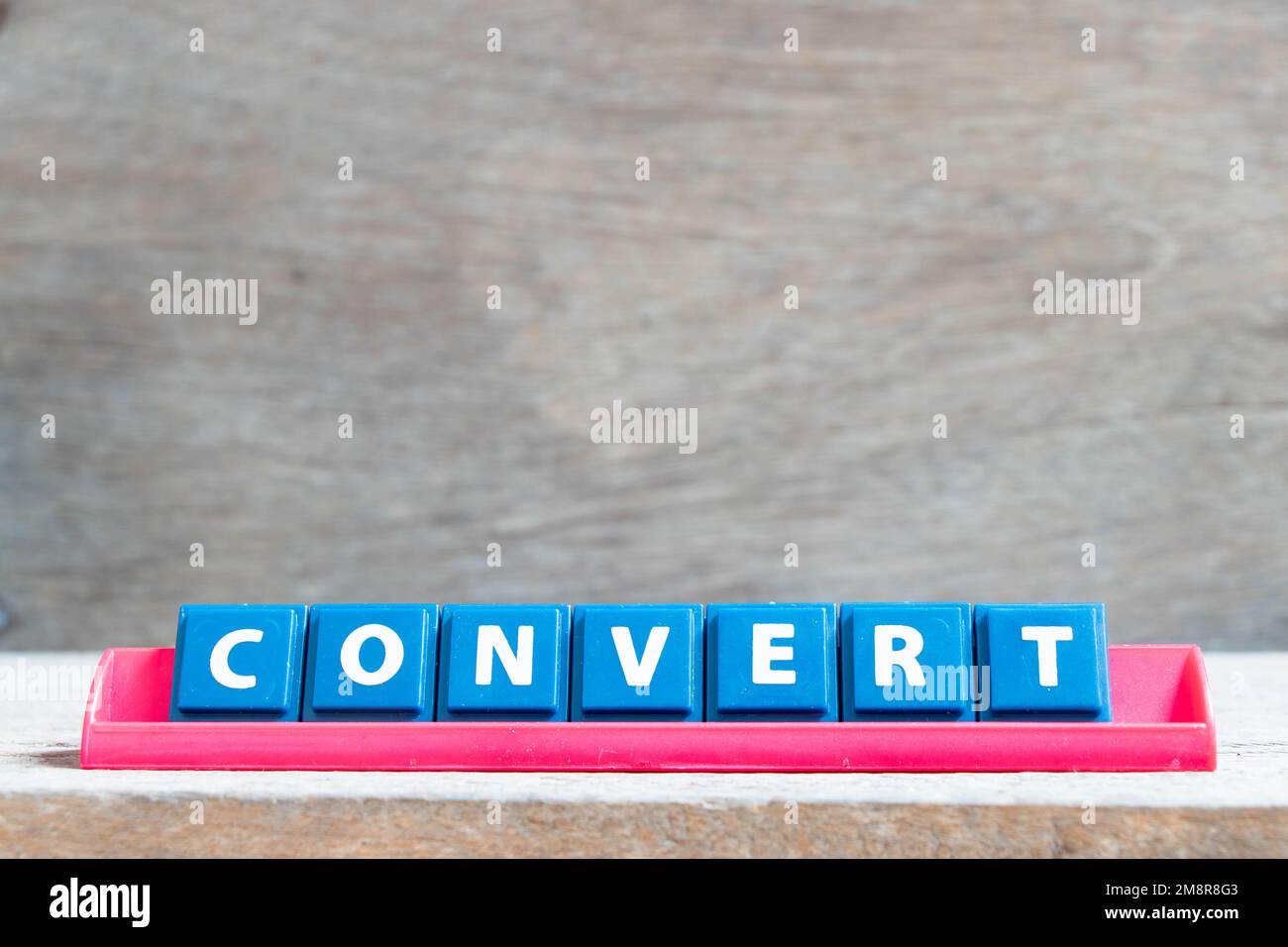 Tile alphabet letter with wordconvert  in red color rack on wood background Stock Photo