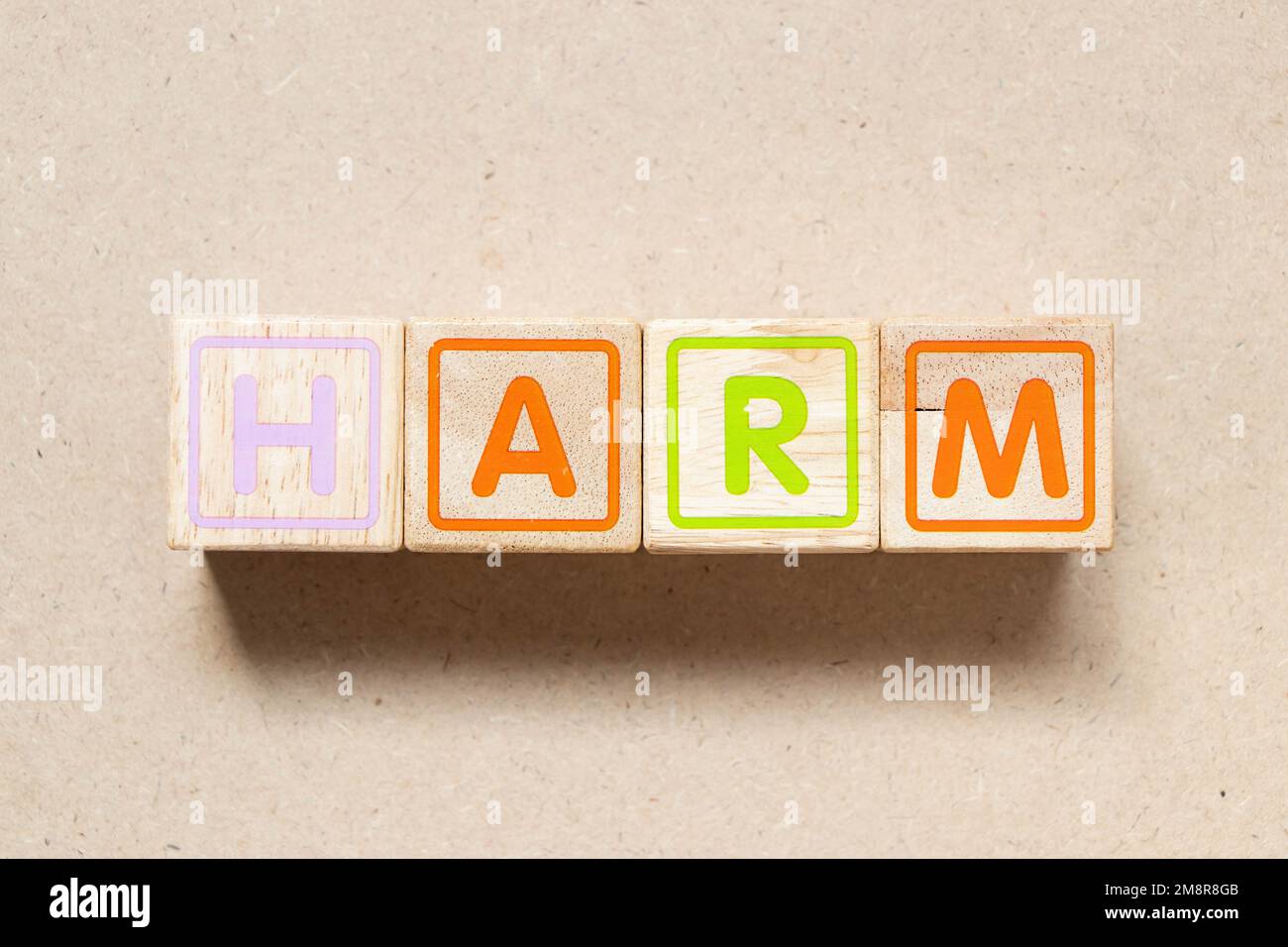 Color letter block in word harm on wood background Stock Photo - Alamy