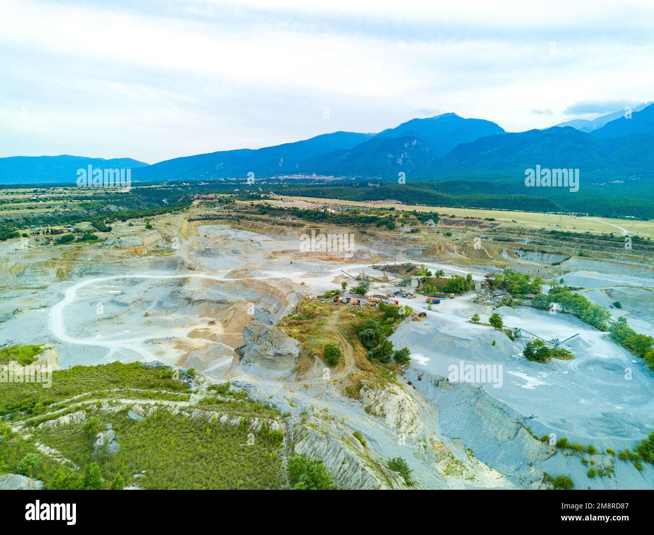 Large wild sand craters in nature of vegetative Montenegro and modern equipment and machines for the extraction of pure white natural sand against the Stock Photo