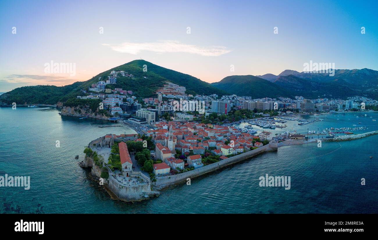 Panorama of sea port with small ships and boats for excursions on the Adriatic Sea near the ancient historical island of St. Stevan in the evening sun Stock Photo