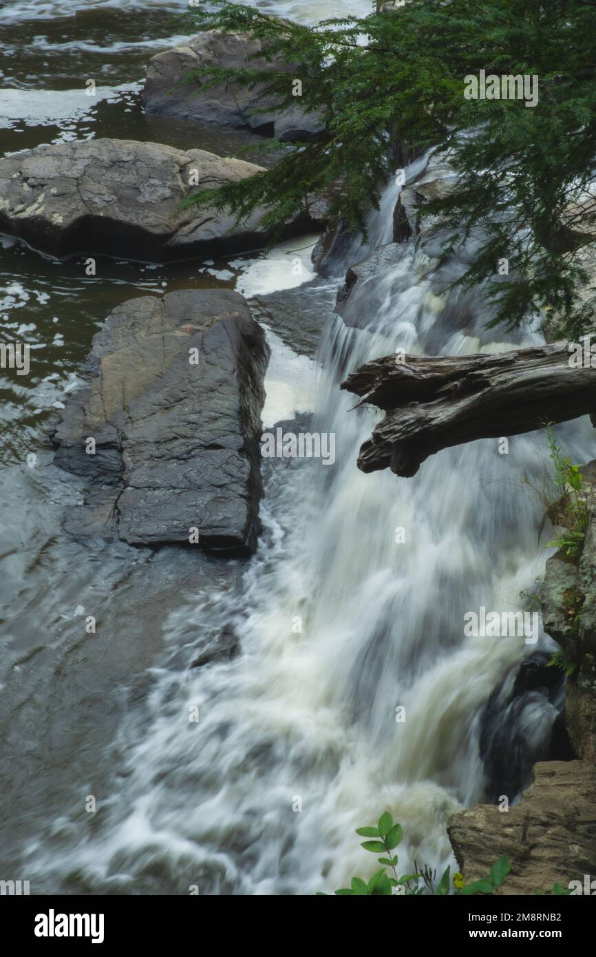 A vertical shot of a waterfall flowing down the rocks Stock Photo - Alamy