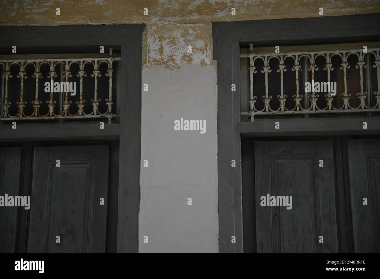 Antique grey wooden window shutters with handcrafted wrought iron