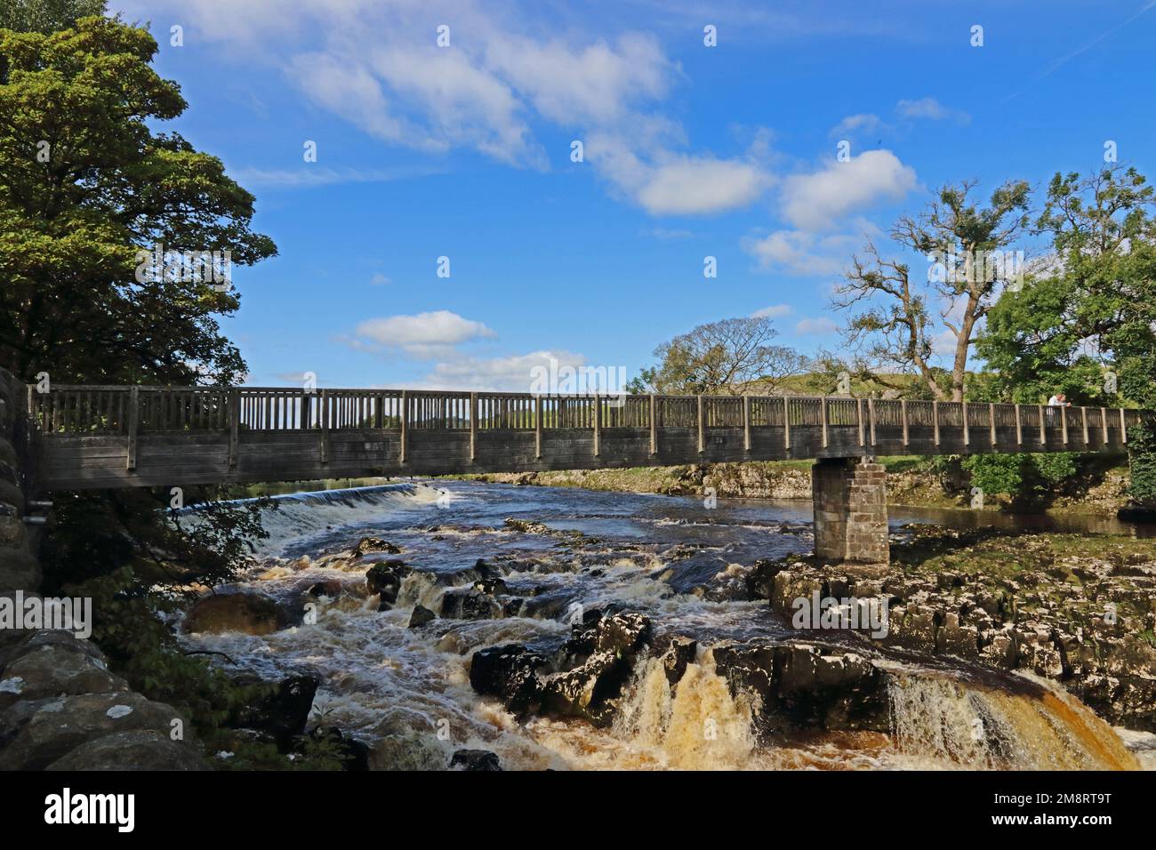 Footbridge across waterfalls on River Wharfe, Linton, Grassington Stock Photo