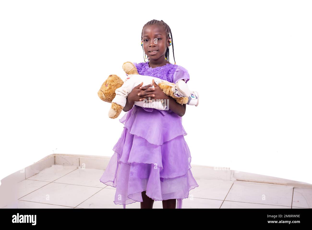 portrait of a cute little girl holding her teddy bear looking at the ...