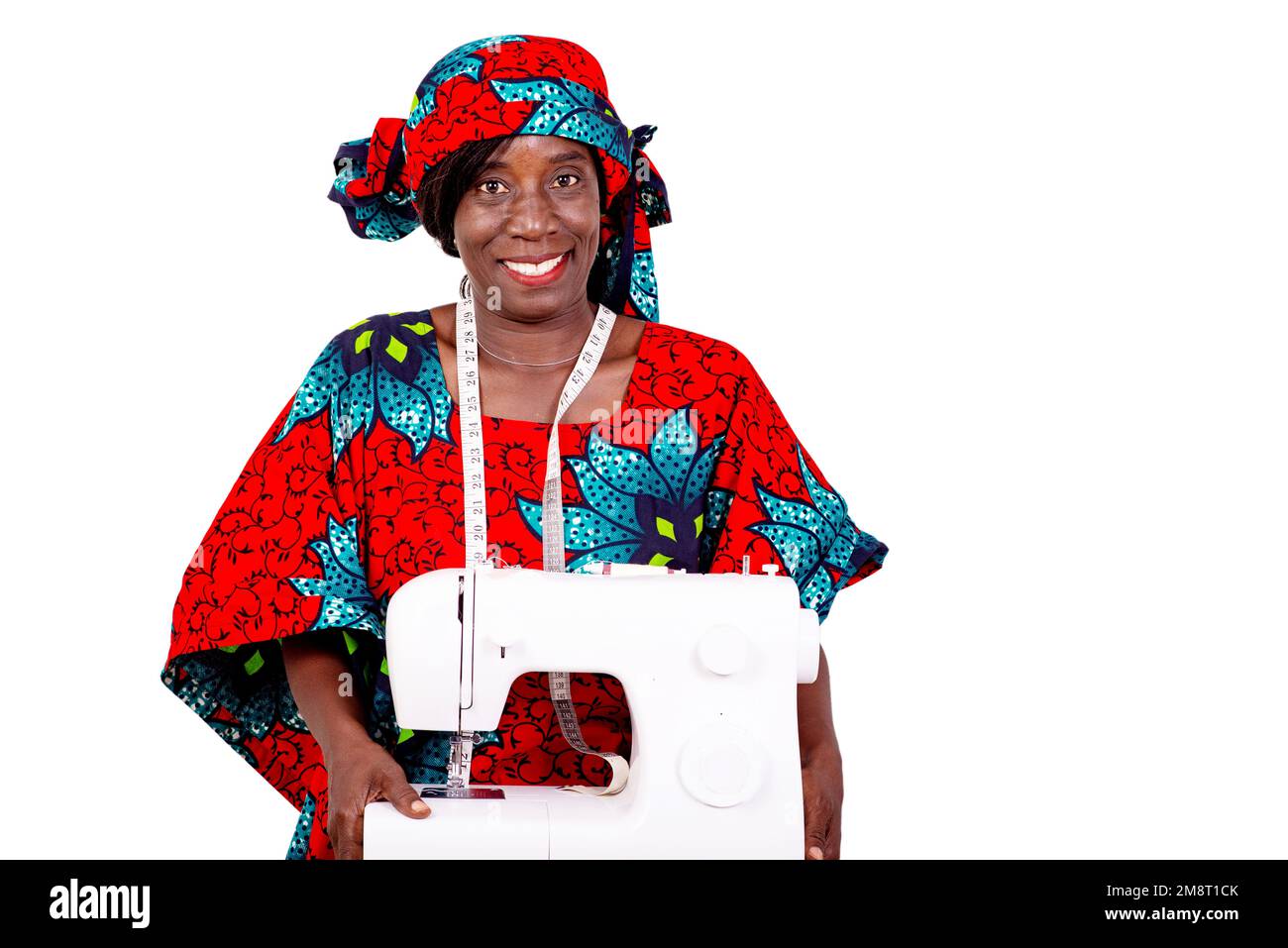 a seamstress in traditional attire standing against white background