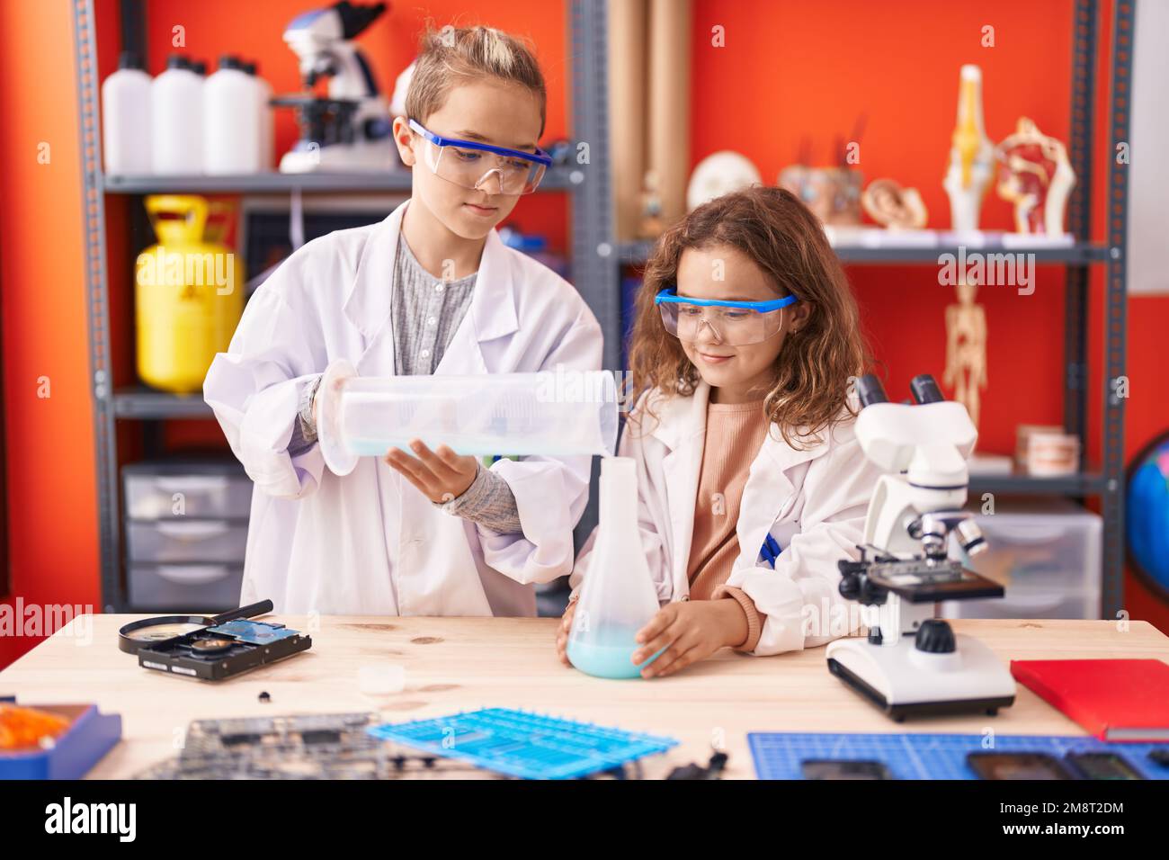 Two Kids Students Pouring Liquid On Test Tube At Laboratory Classroom Two Kids Students Pouring Liquid On Test Tube At Laboratory Classroom