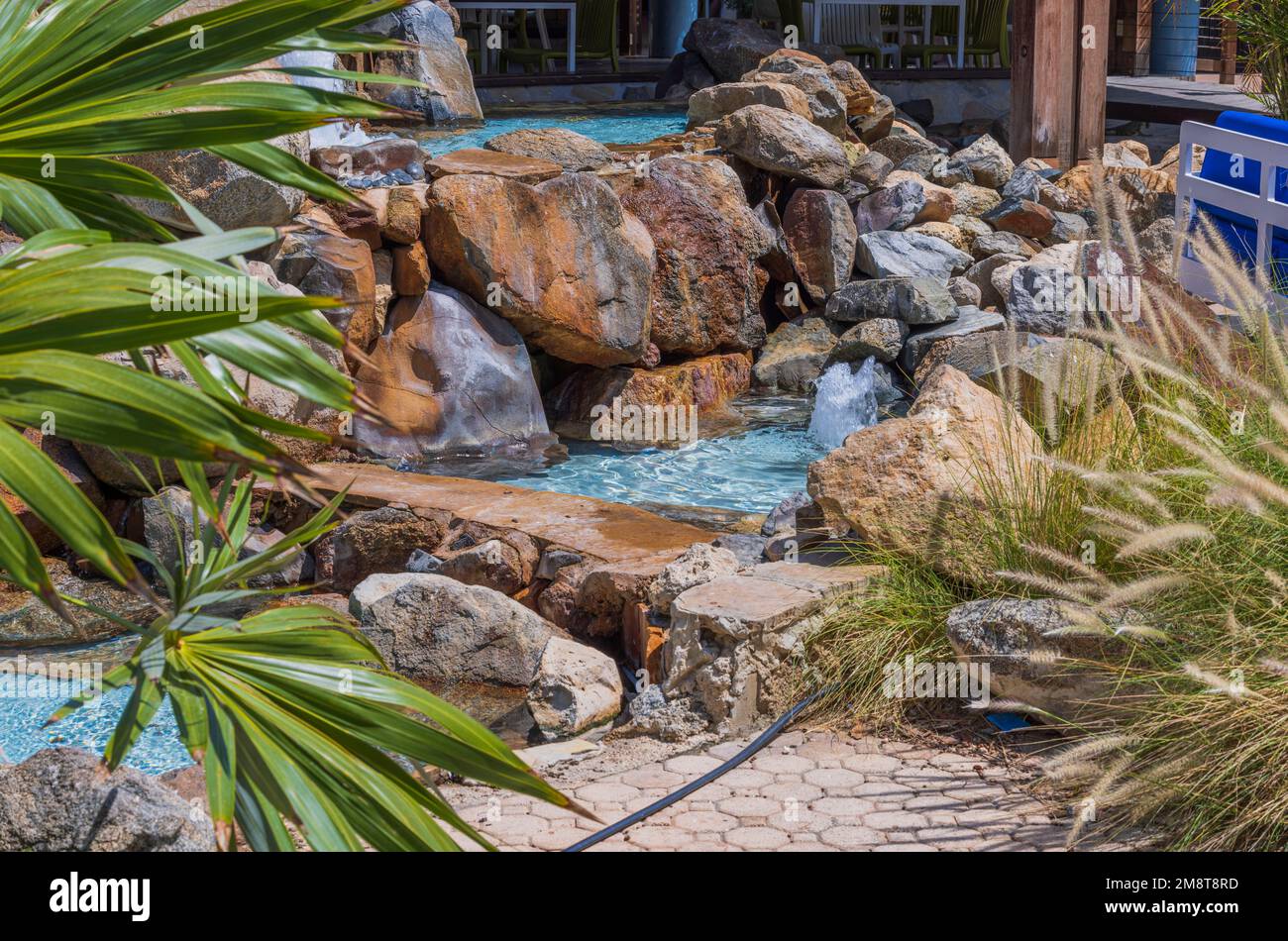 Close up view of interior of fountain with artificial pond among stones on territory of hotel. Aruba. Stock Photo