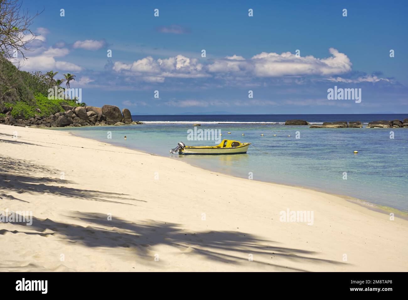 Mahe Seychelles, Anse forbans beach calm seas and white sand. blue sky and low tideland docking boat Stock Photo