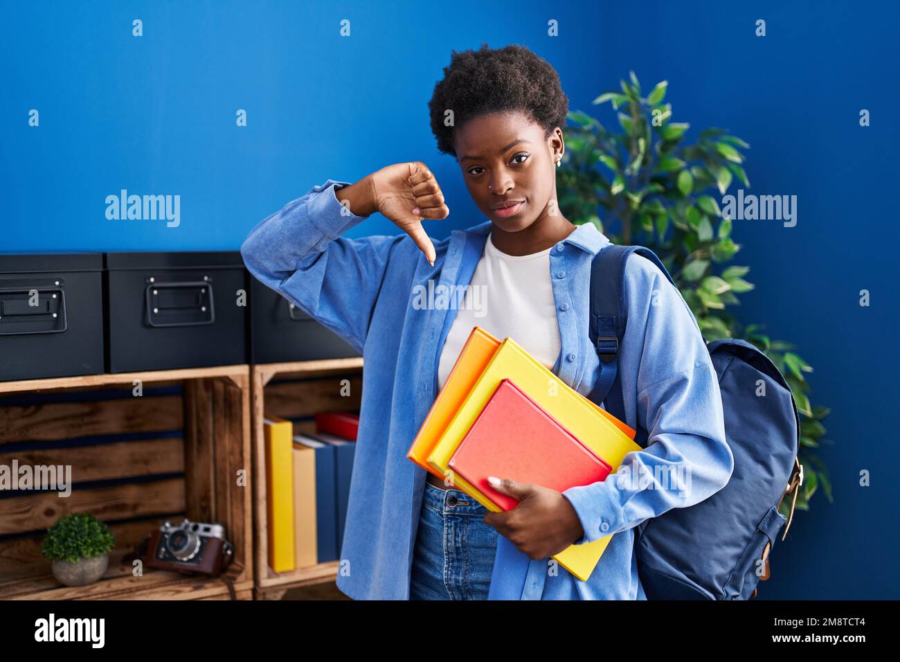 African american woman wearing student backpack and holding books with ...