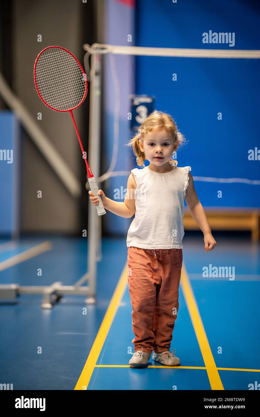 Little girl three years old playing badminton in sport wear on indoor court Stock Photo Alamy