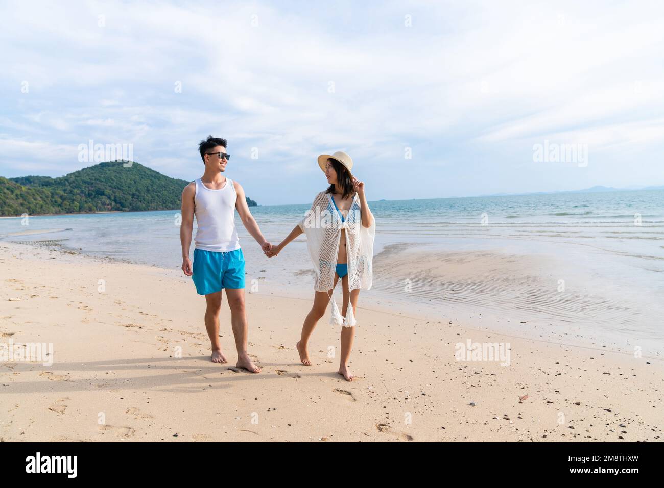 Happy young couple walking on the beach Stock Photo - Alamy