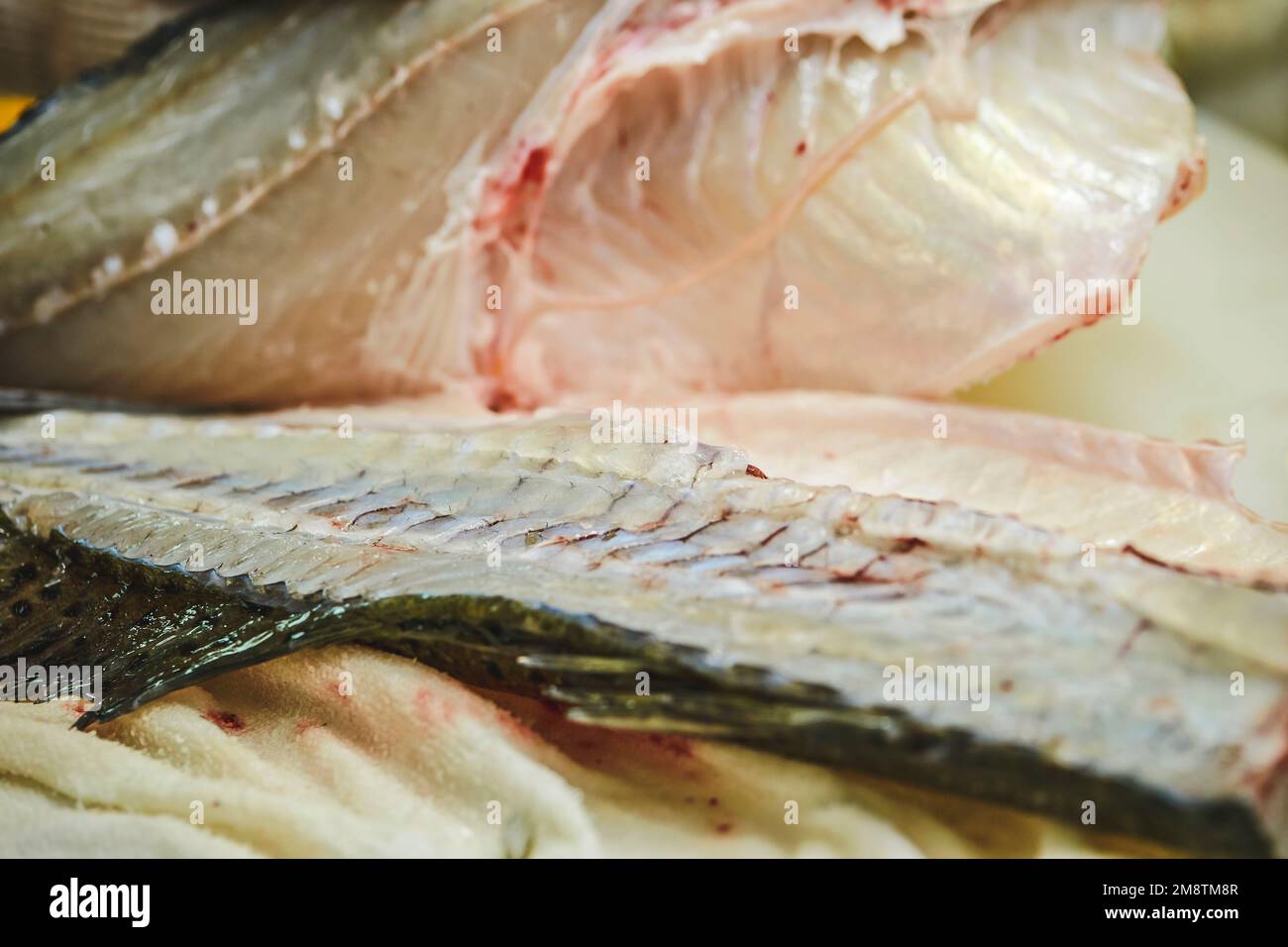 Fish being cut on a chopping board Stock Photo - Alamy
