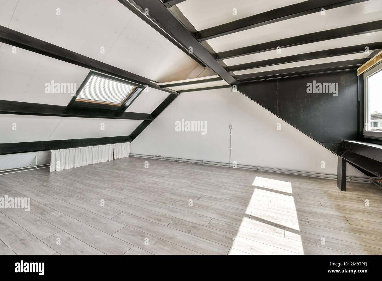 an empty room with wood flooring and black trim on the walls in this photo is taken from above it Stock Photo