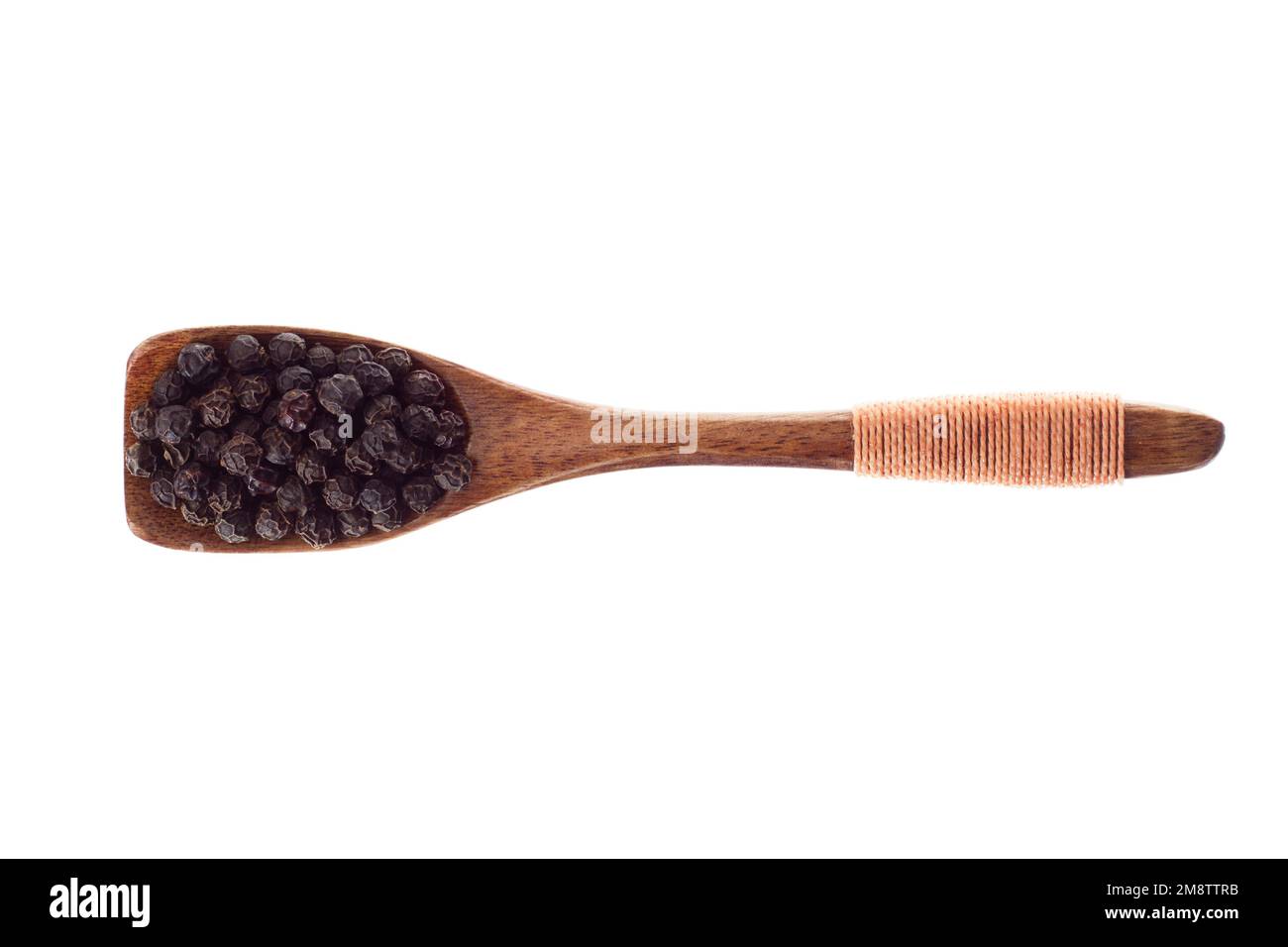 Black pepper grains in a spoon, top view. condiment isolated on white